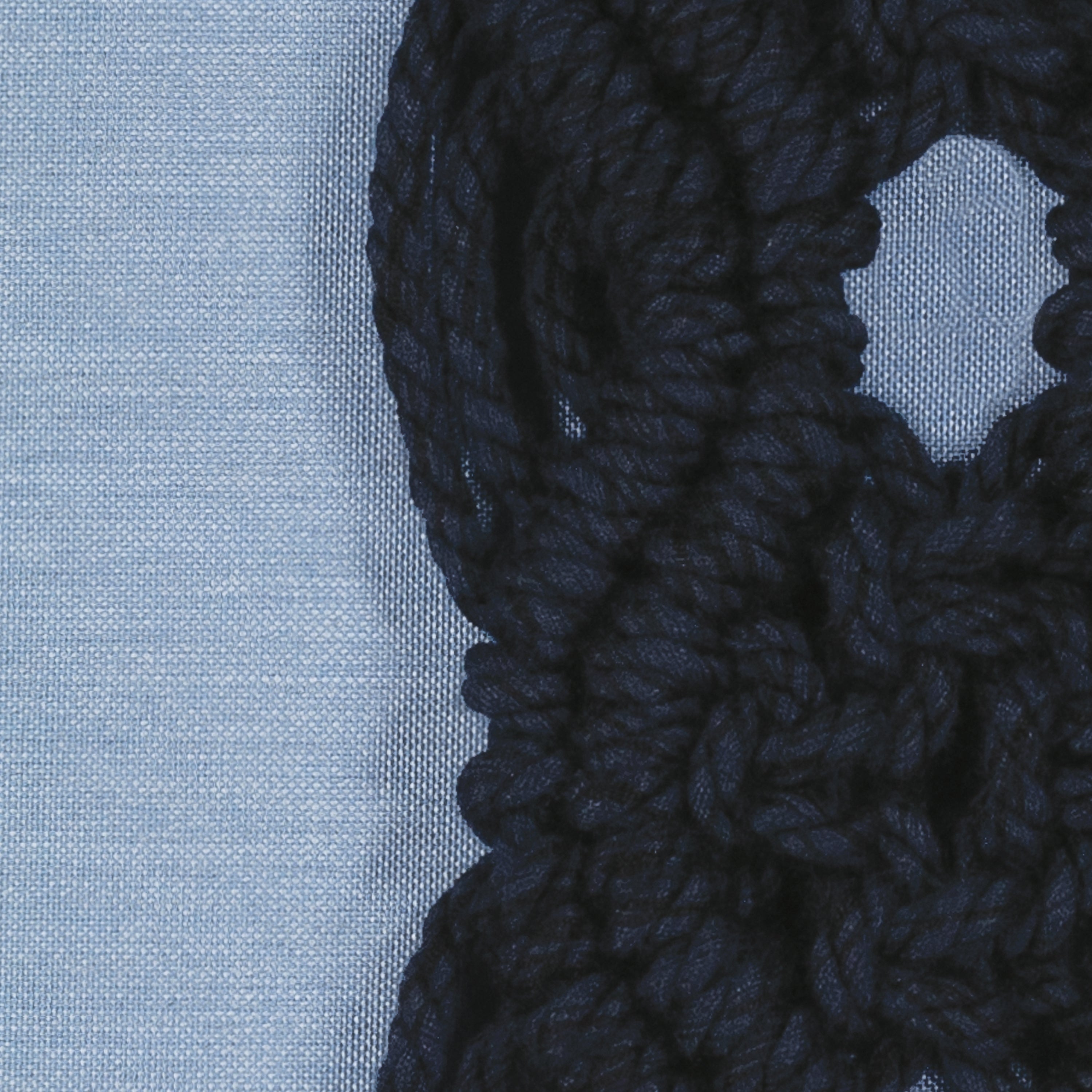 Detail image of Blue pillow with dark blue macrame detailing as center band, lumbar size for bold indoor and outdoor decor