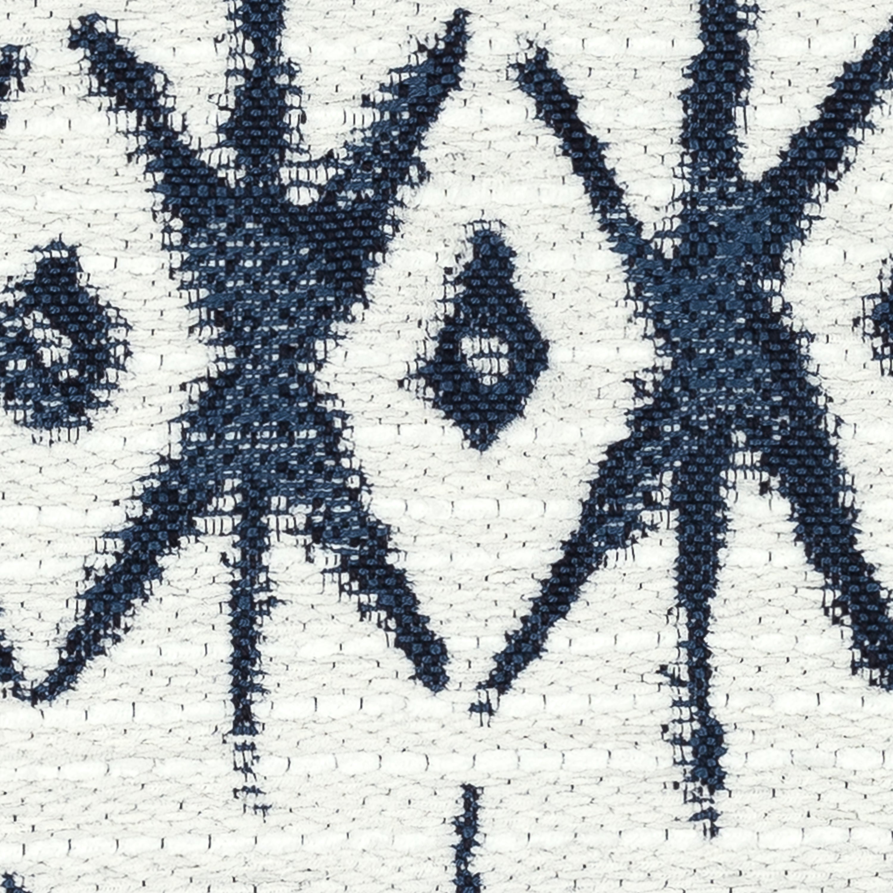 Detail image of Textured ivory pillow with indigo geometric pattern in lumbar size for bold indoor and outdoor decor