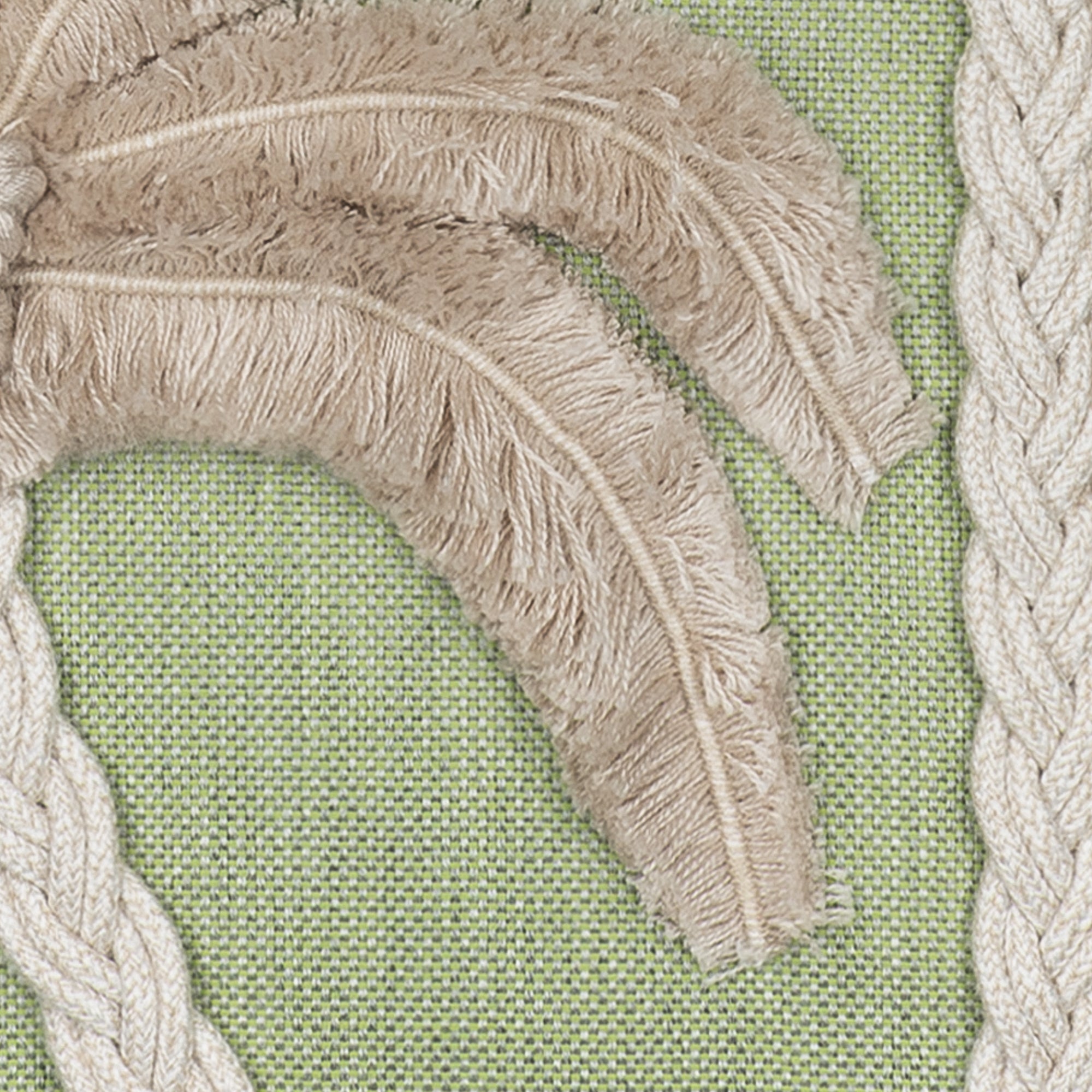 Close-up of textured fabric with leaf pattern on a green background