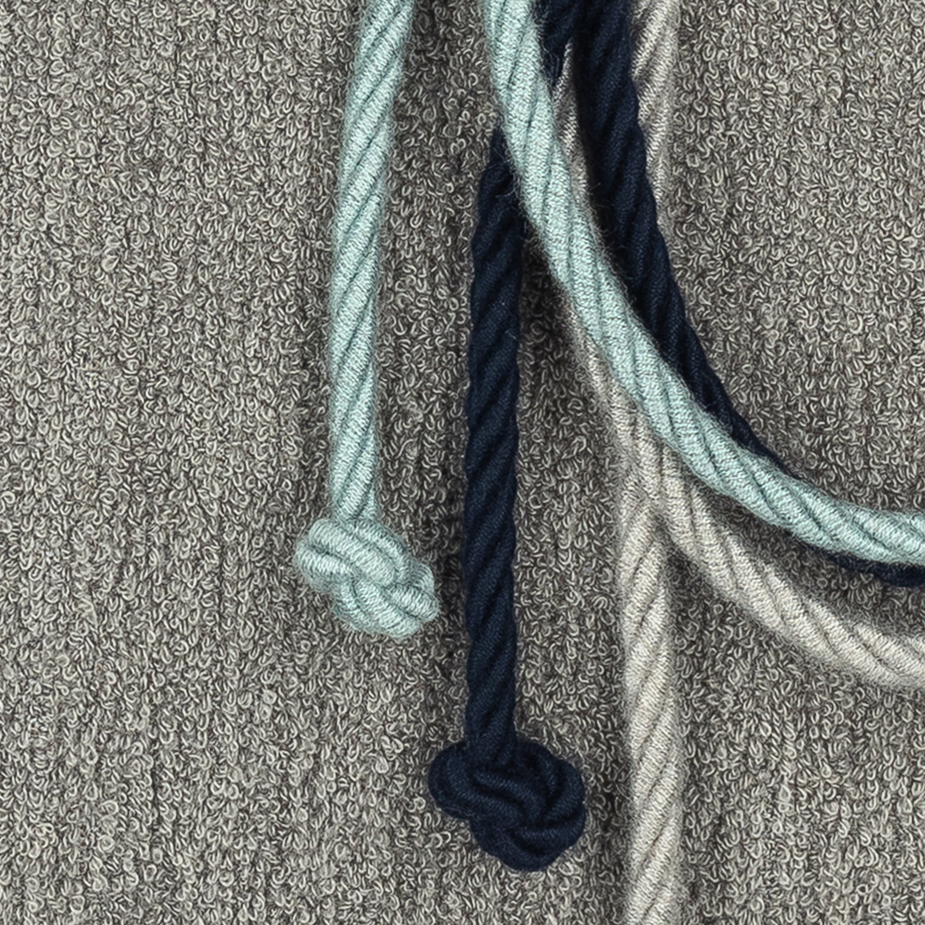 Detail image of Gray textured outdoor pillow with rope detailing in lumbar size for modern patio decor