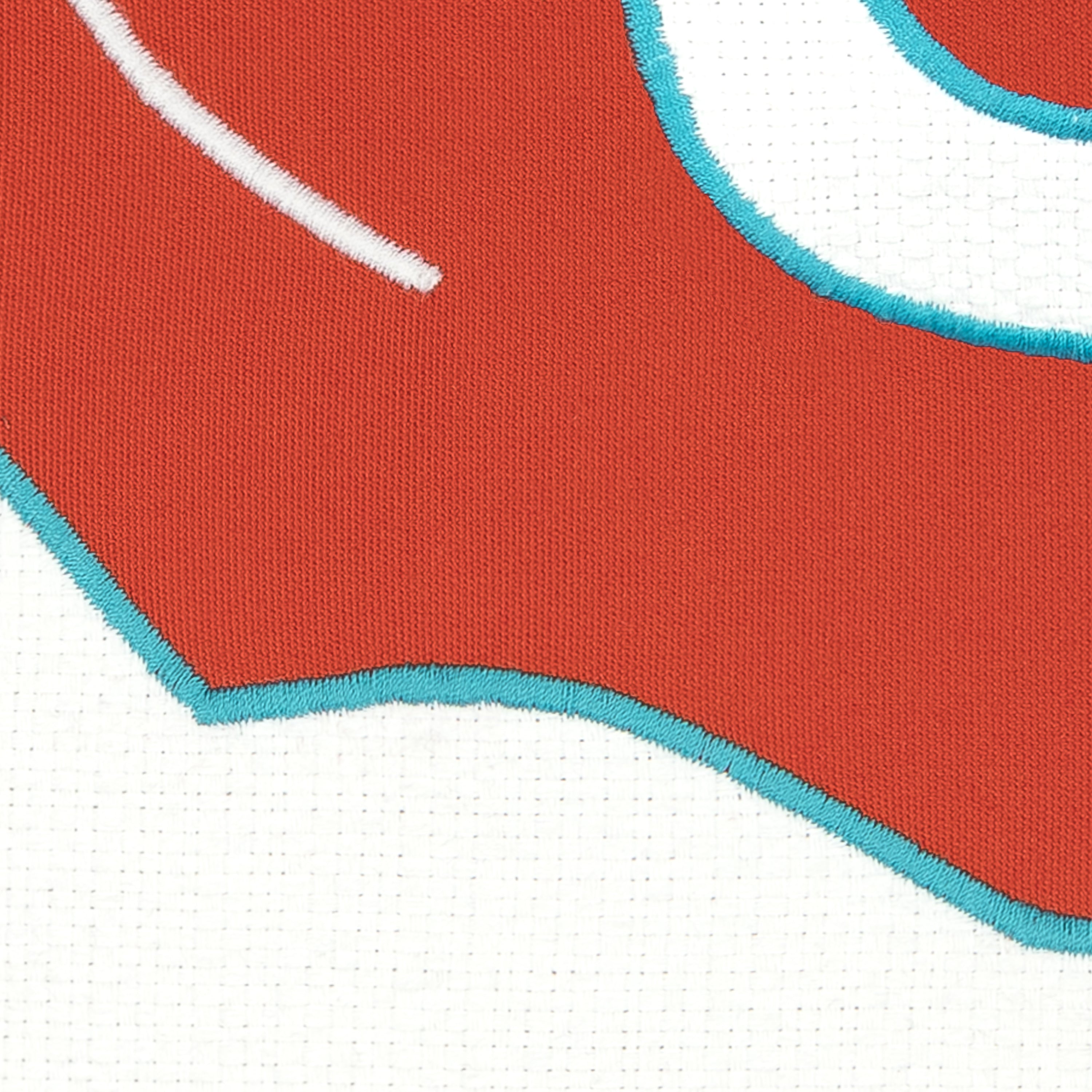 Detail image of Red and white western inspired design on outdoor pillow with aruba tassels for vibrant patio decor