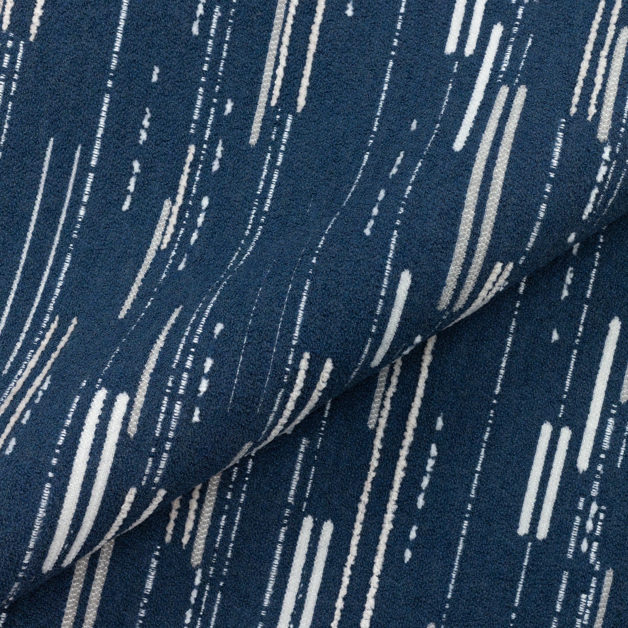 Close shot texture image of Artful dashed indigo outdoor safe boucle and chenille fabric with contemporary flair