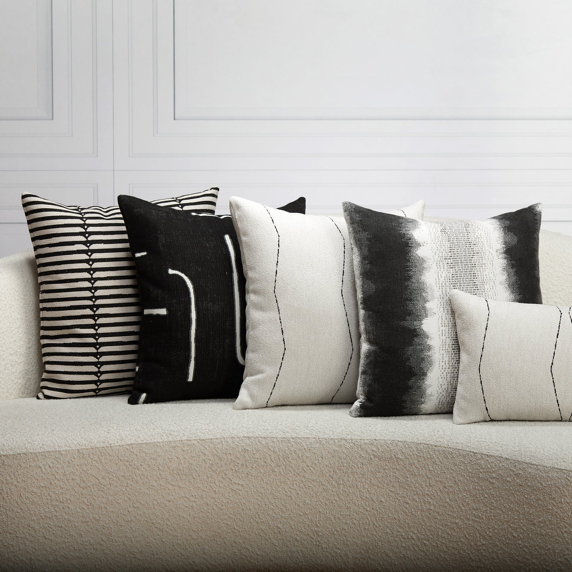 Indoor environmental image of pillows in Ebony black outdoor safe woven fabric with abstract linear pattern – Instinct Ebony by Elaine Smith
