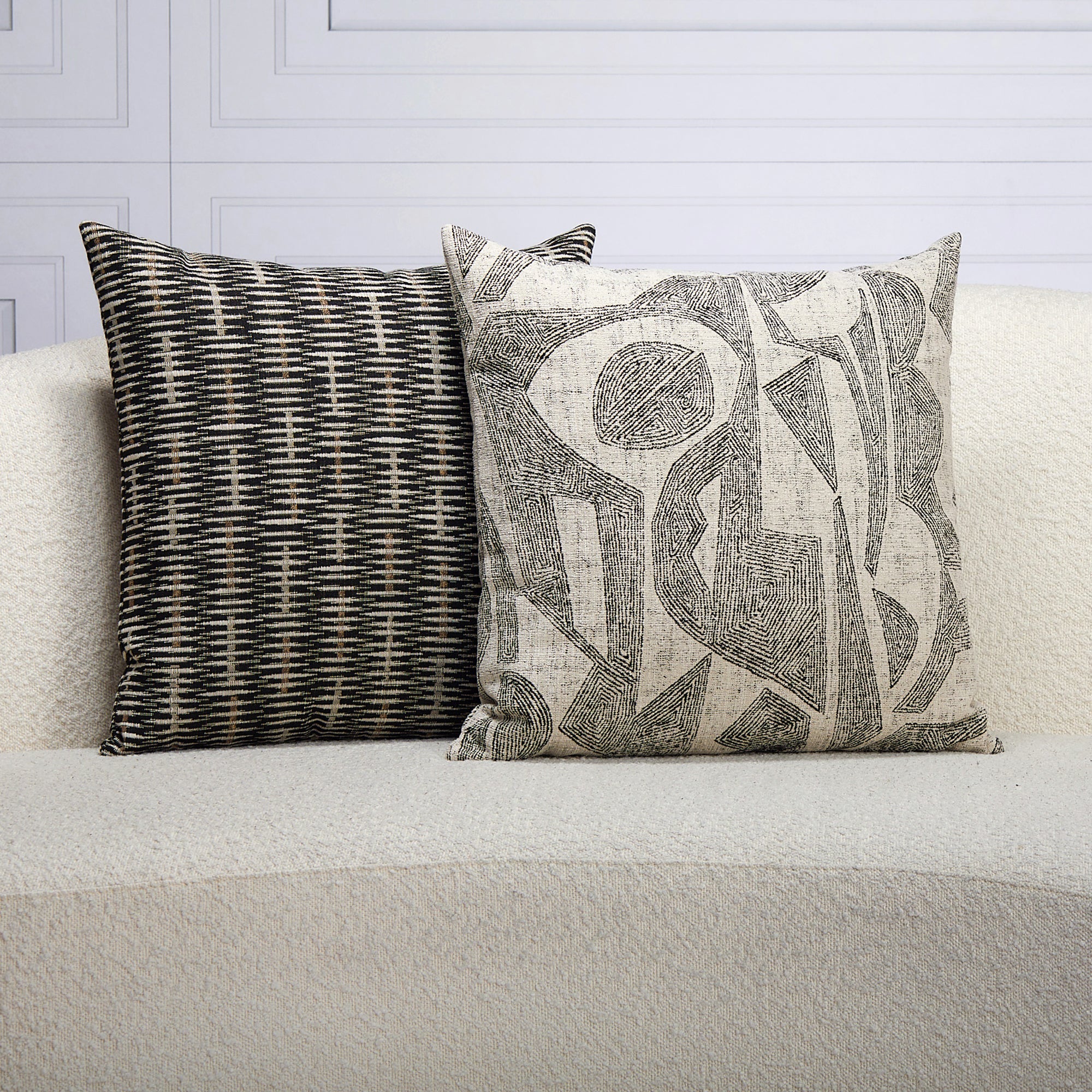 Indoor environmental image of pillows in Ebony-toned geometric outdoor safe fabric with tribal-inspired design