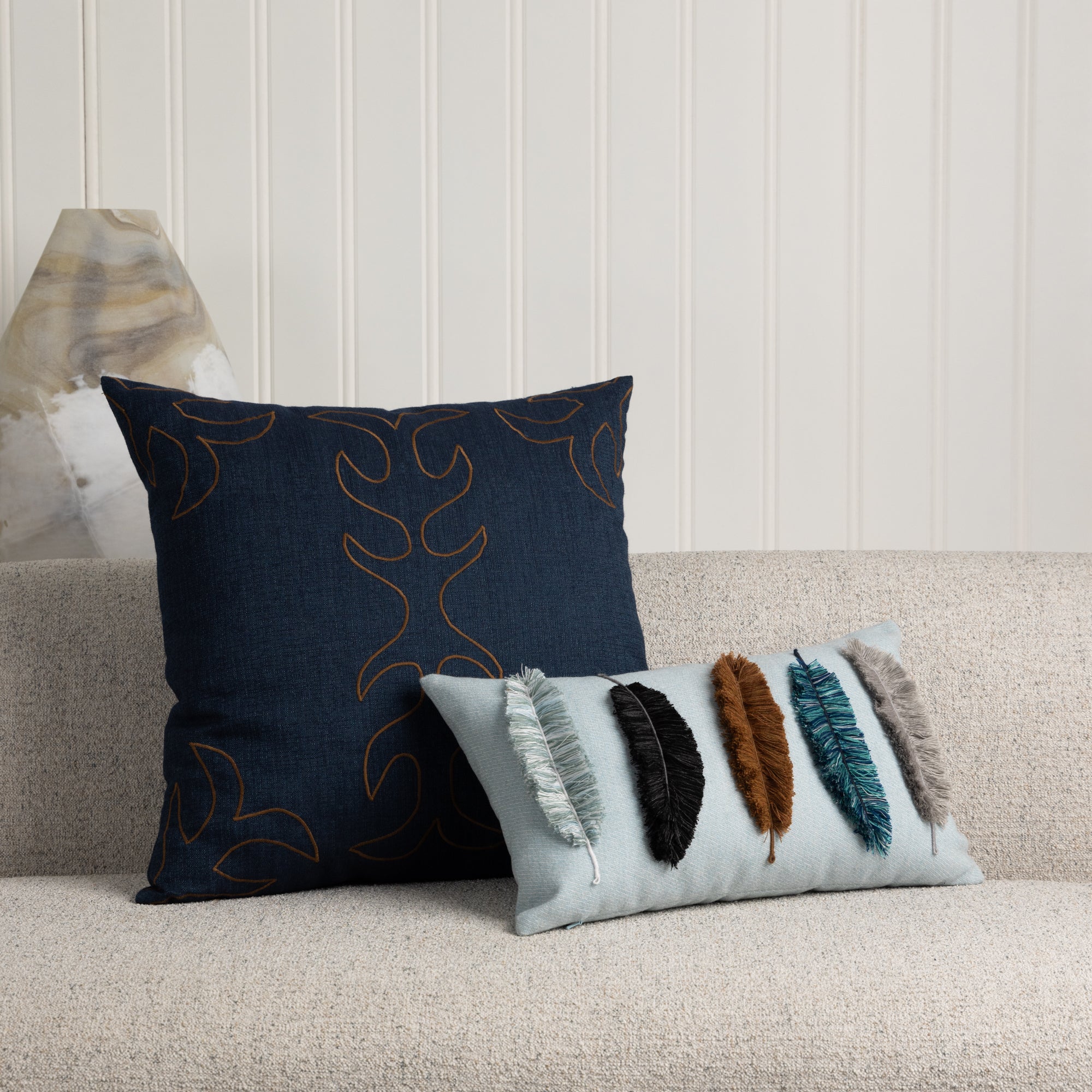 Denim pillow with saddle stitch accents in brown and sky blue lumbar with hand stitched fringe details on ivory sofa