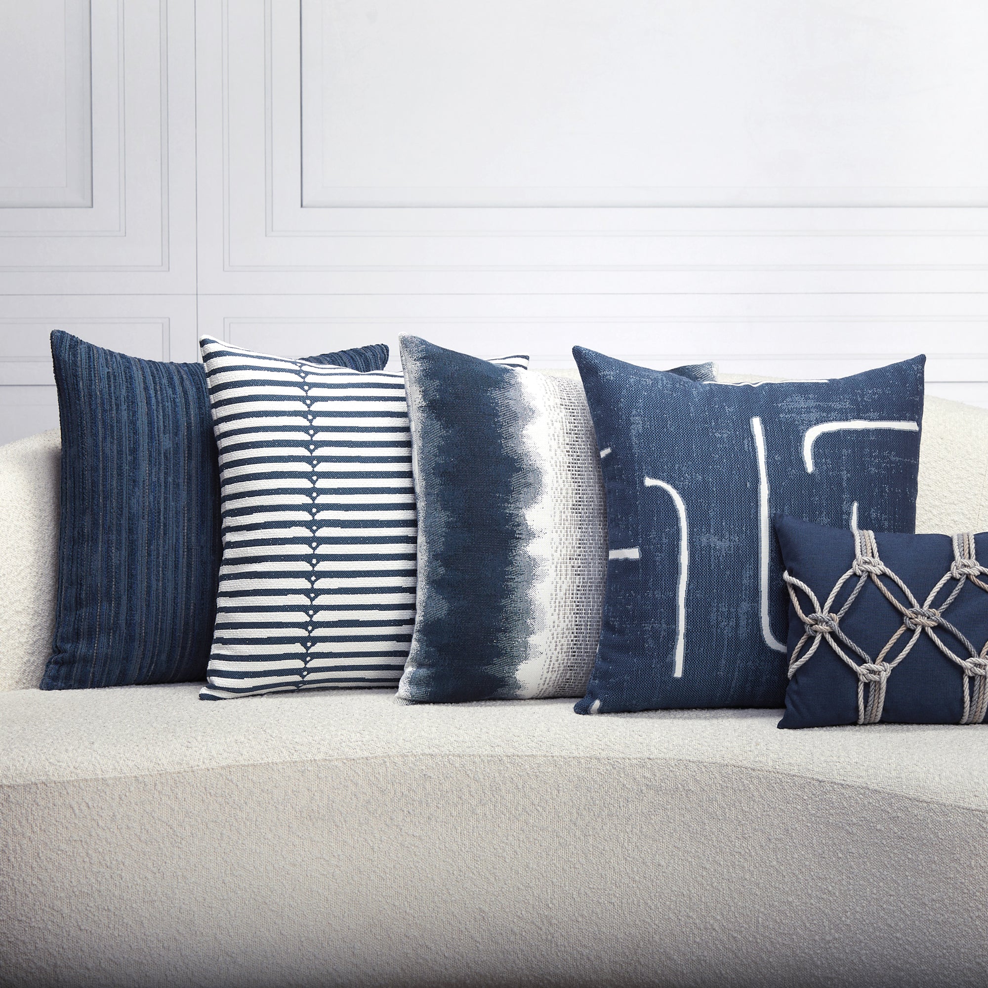 Indoor environmental image of pillows in Modern outdoor safe fabric featuring denim-inspired blue with minimalist stripe accents