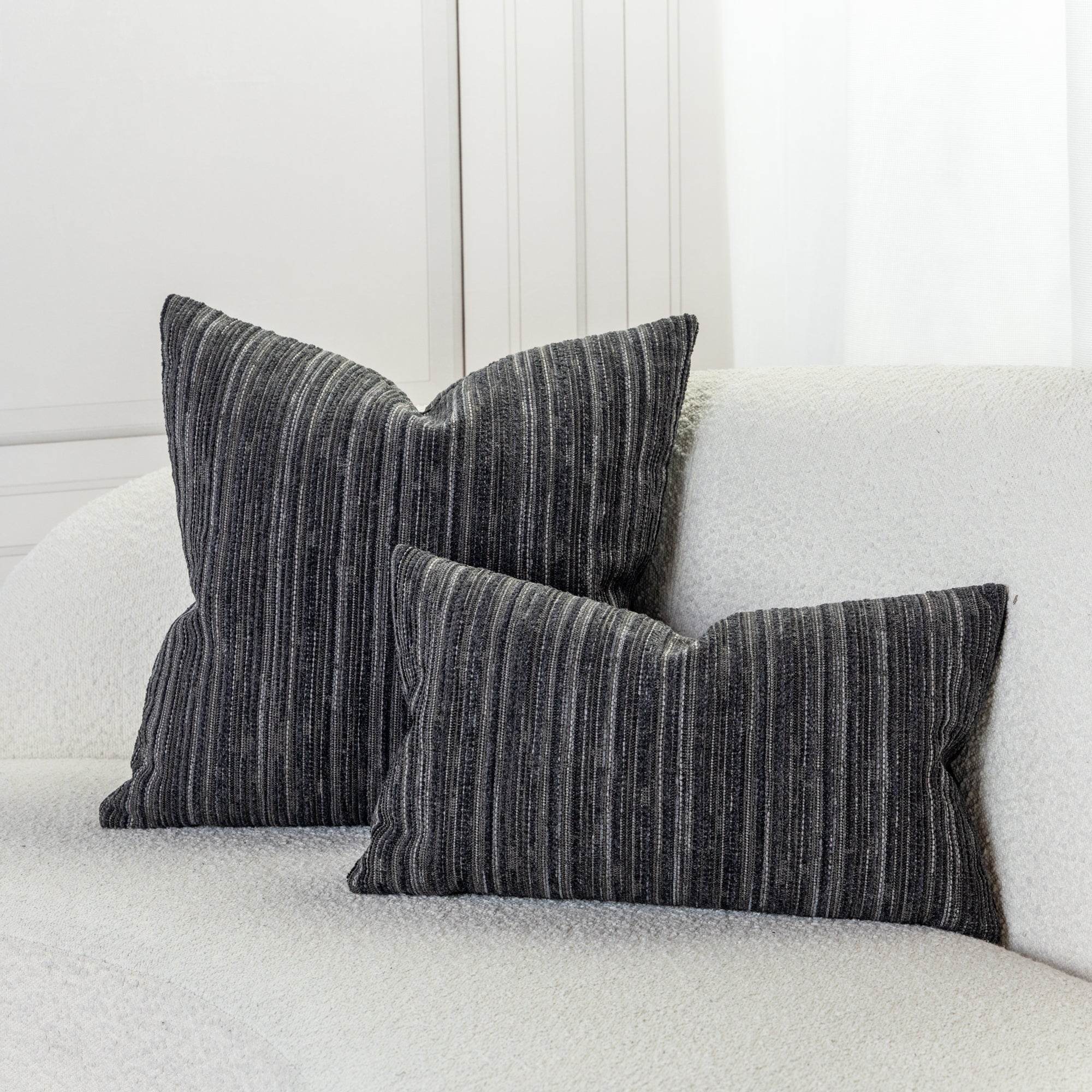 Indoor environmental image of pillows in Elegant stripe outdoor safe chenille woven fabric in charcoal tones