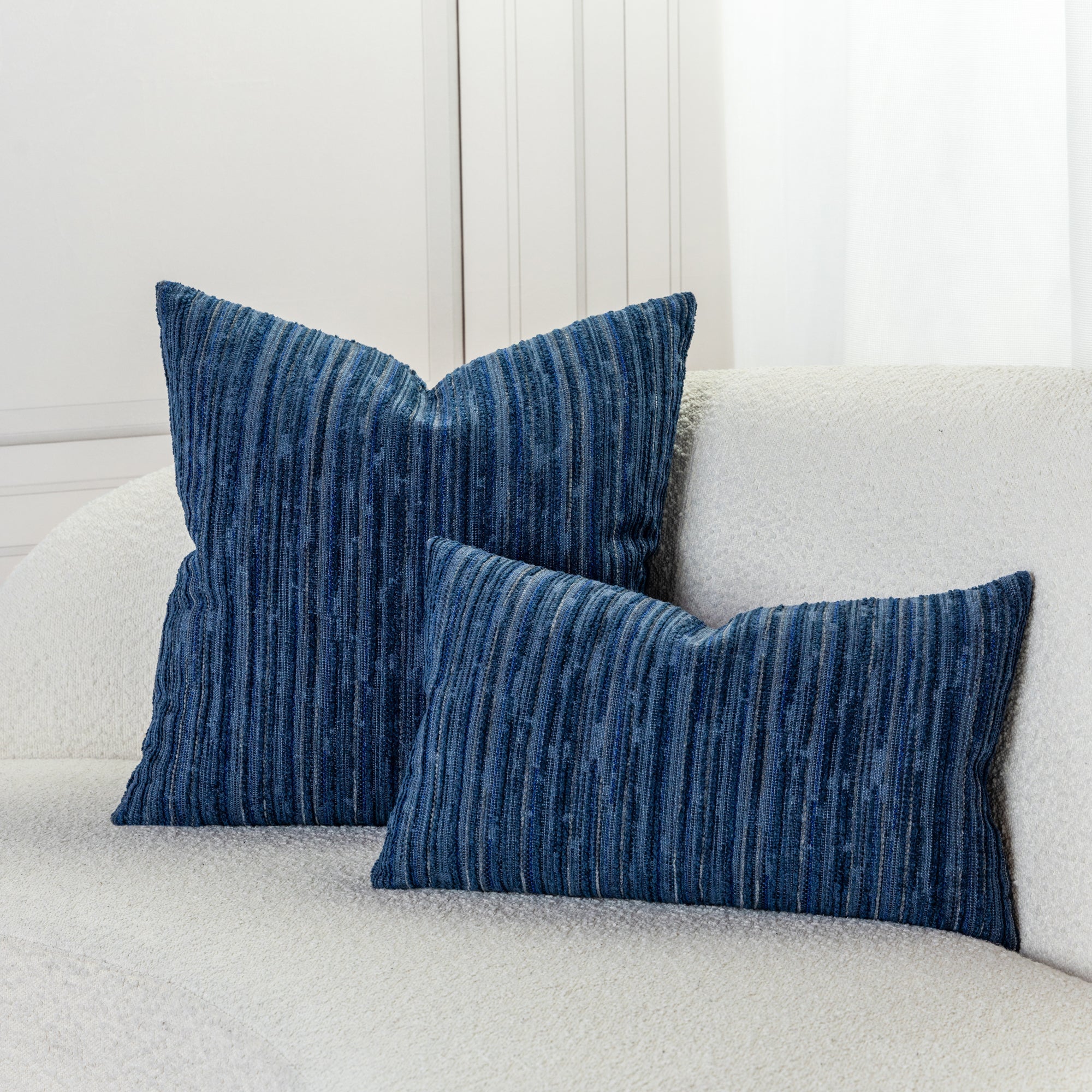 Indoor environmental image of pillows in Patchwork stripe pattern in indigo tones for outdoor safe use