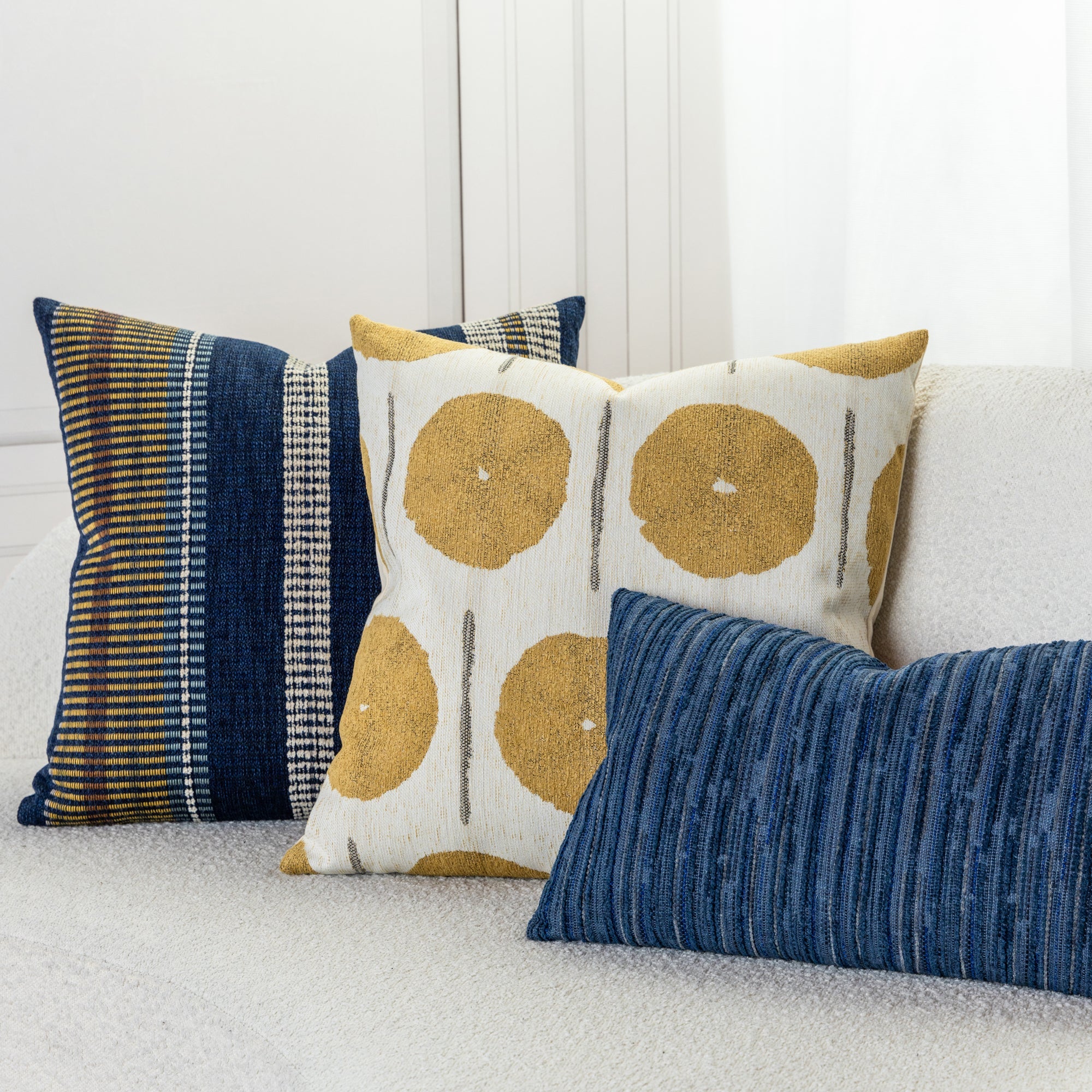 Indoor environmental image of pillows in Patchwork stripe pattern in indigo tones for outdoor safe use