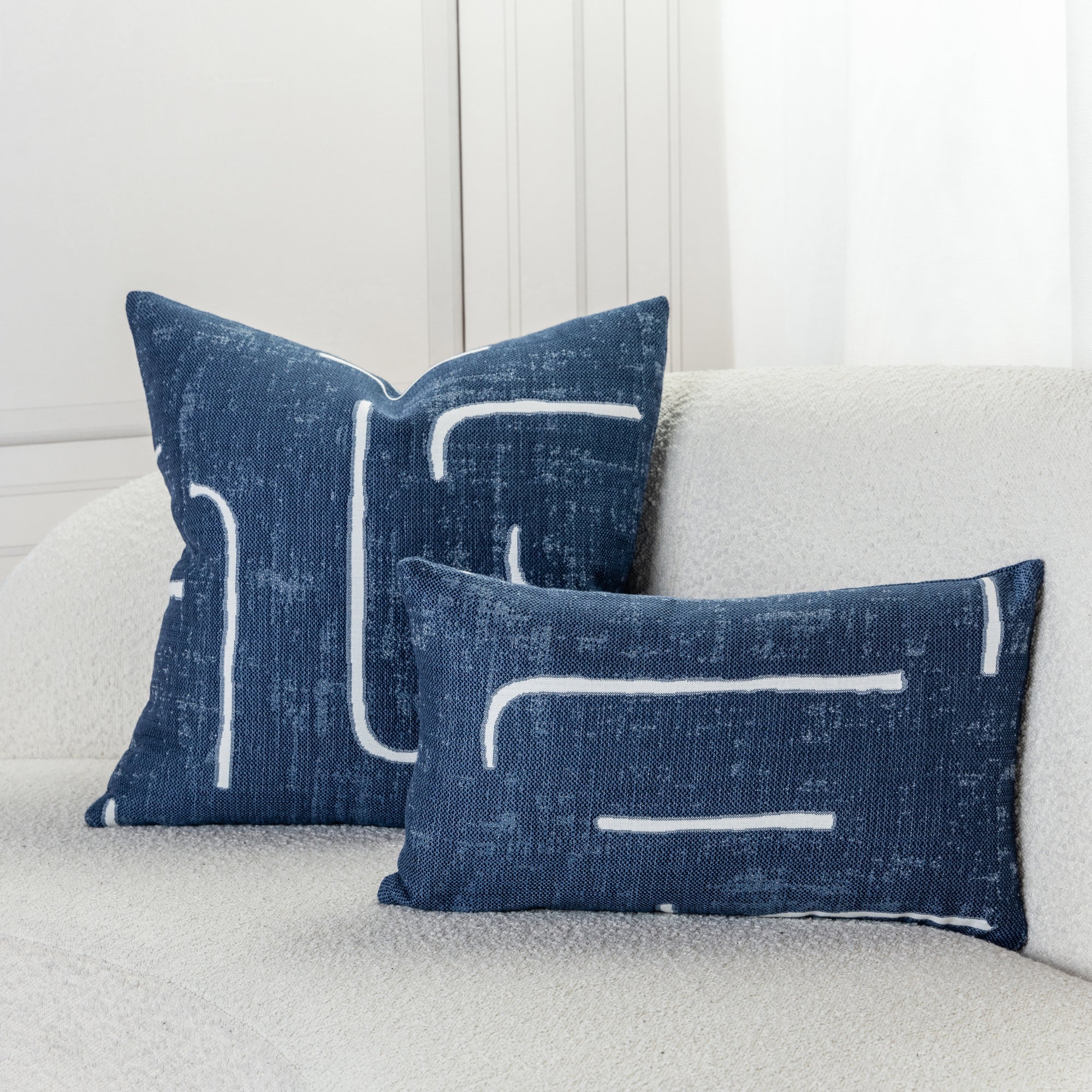 Indoor environmental image of pillows in Soft blue outdoor safe woven fabric with abstract linear design
