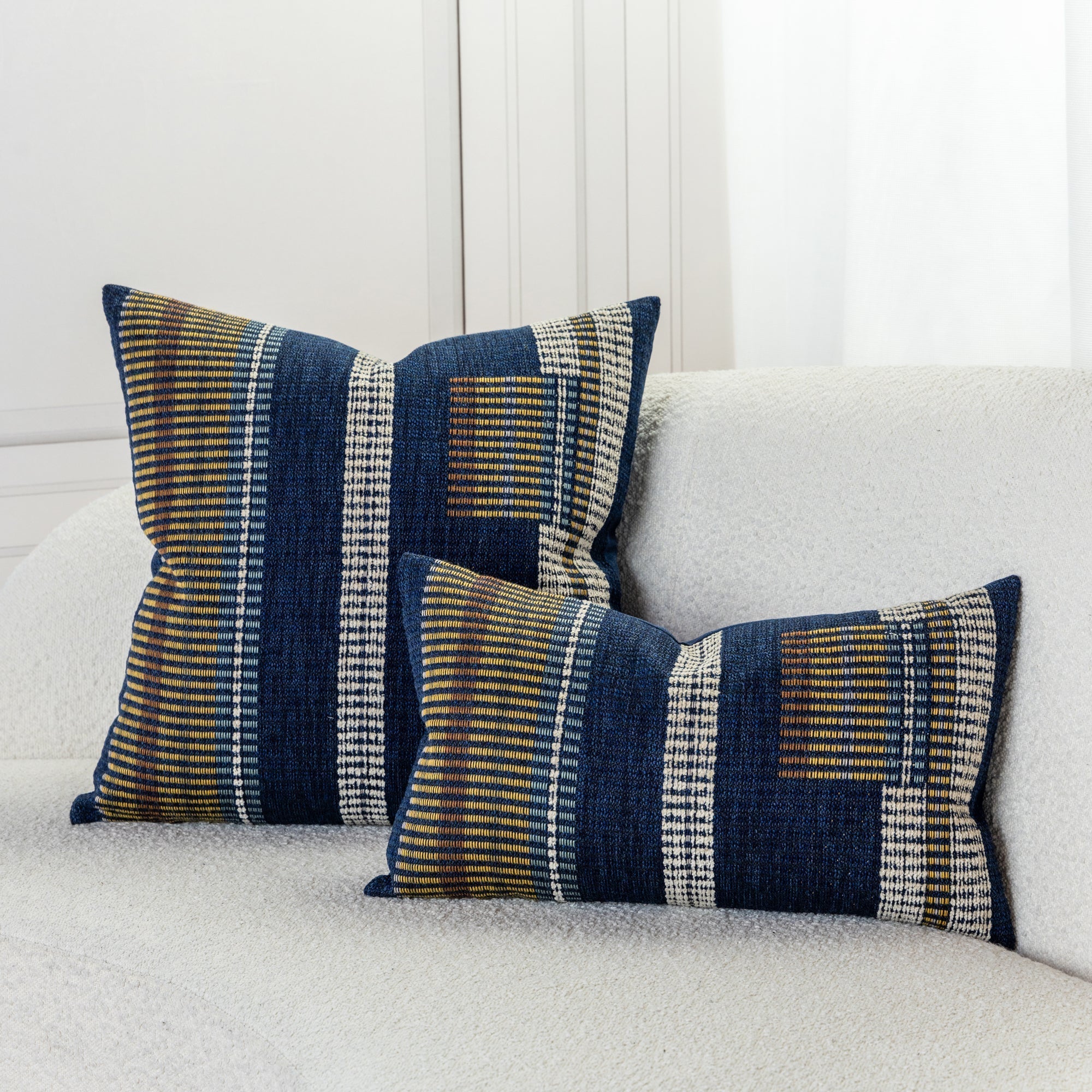 Striped indigo pillow with gold and oatmeal accents on ivory sofa by elaine smith