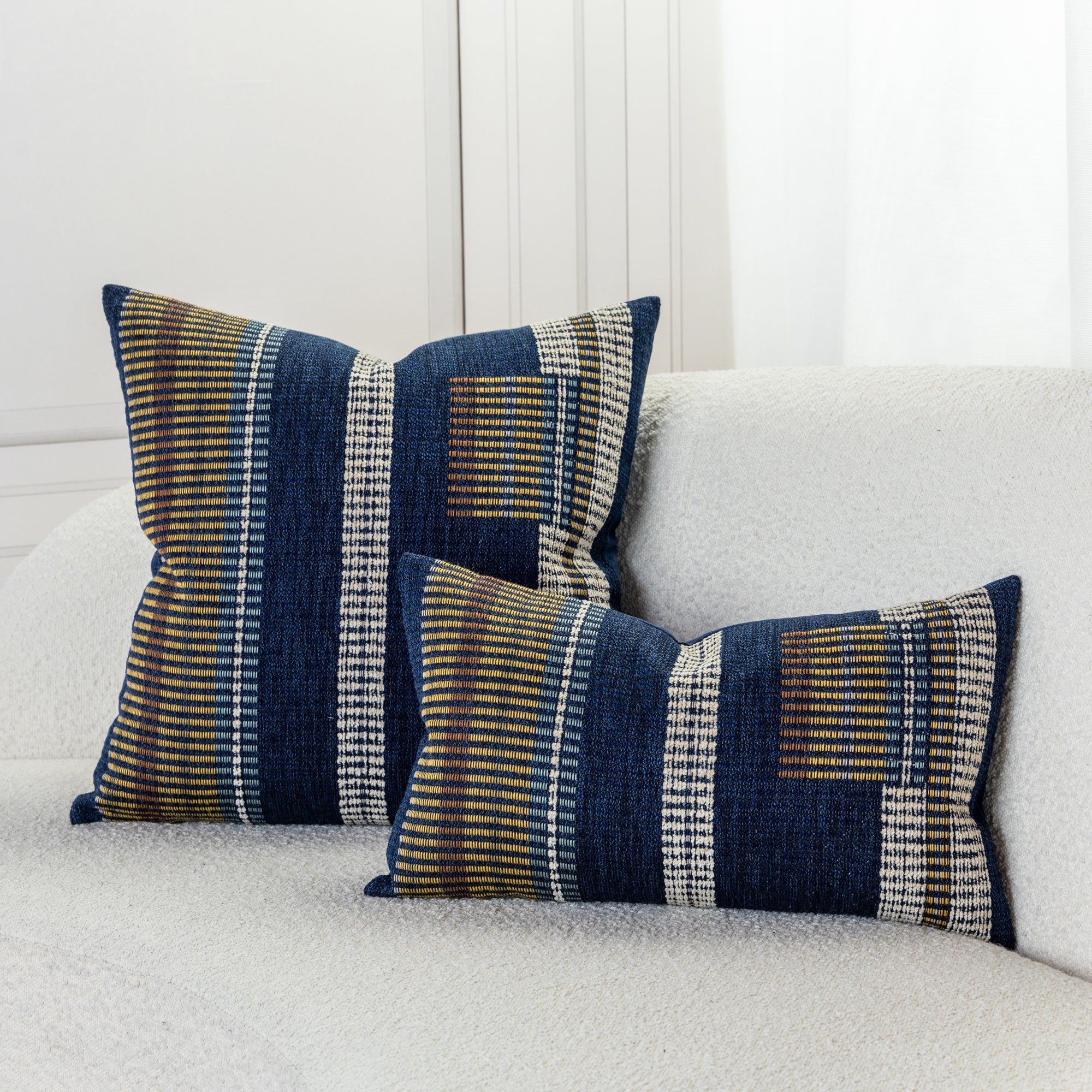 Striped indigo pillow with gold and oatmeal accents on ivory sofa by elaine smith