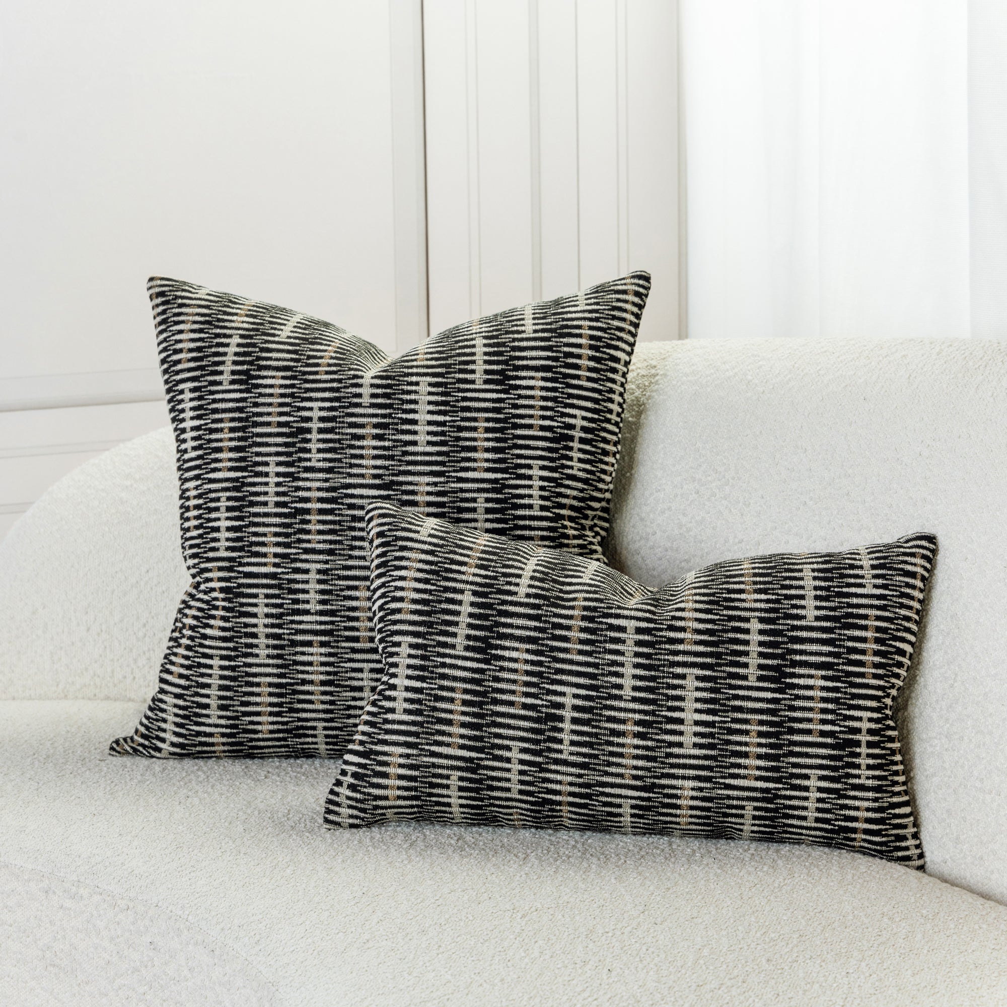 Basketweave woven textured accent pillows in black and beige on ivory sofa