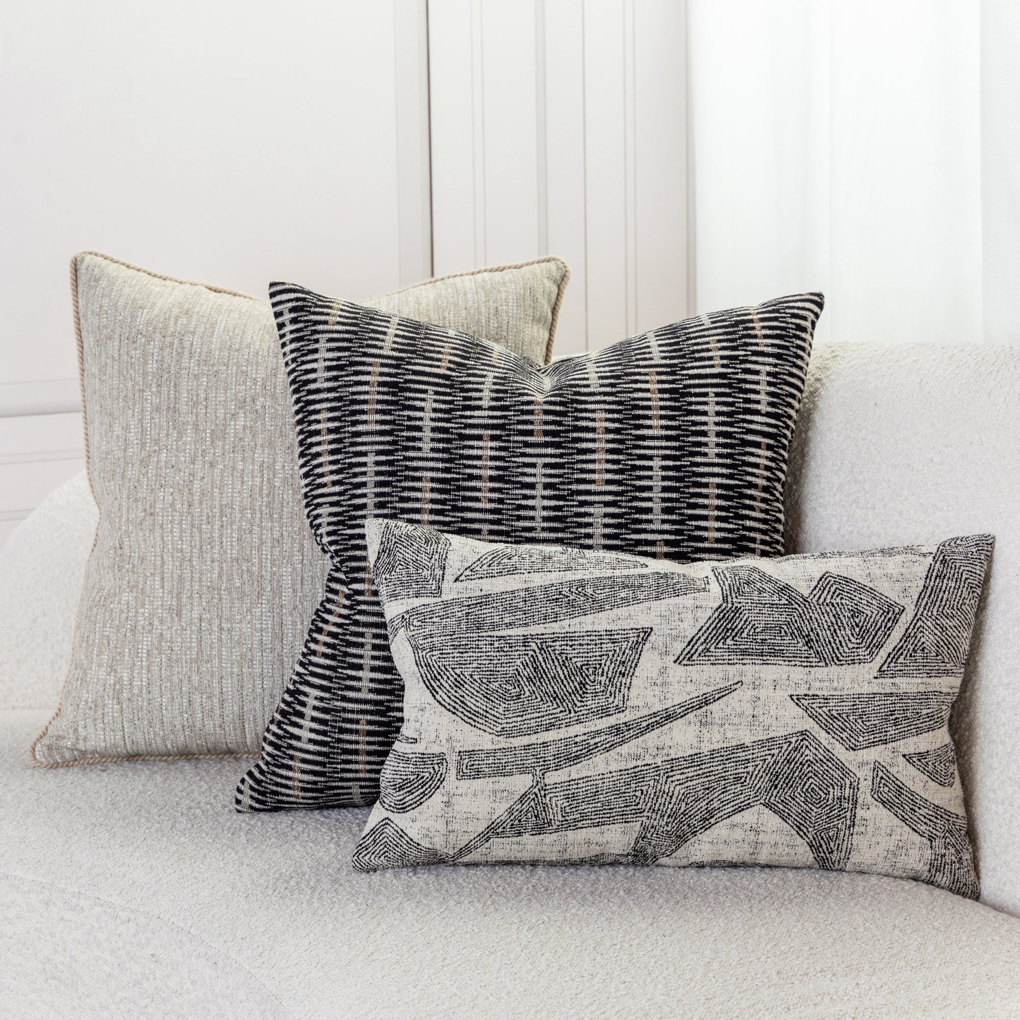 Two woven textured accent pillow in black and beige on ivory sofa by elaine smith