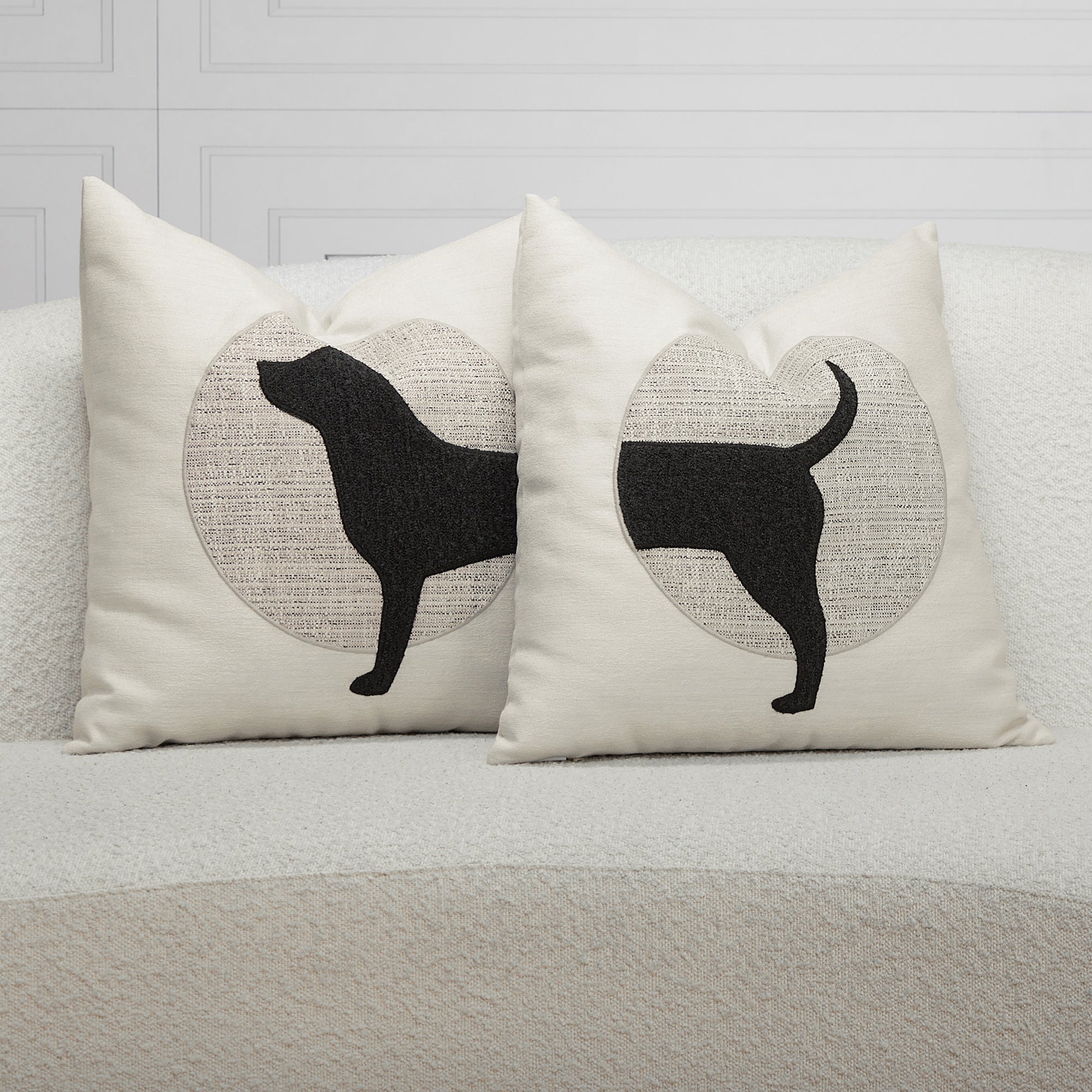 Indoor enviro image of a black and ivory dog pillow on an ivory sofa, safe for outdoor use