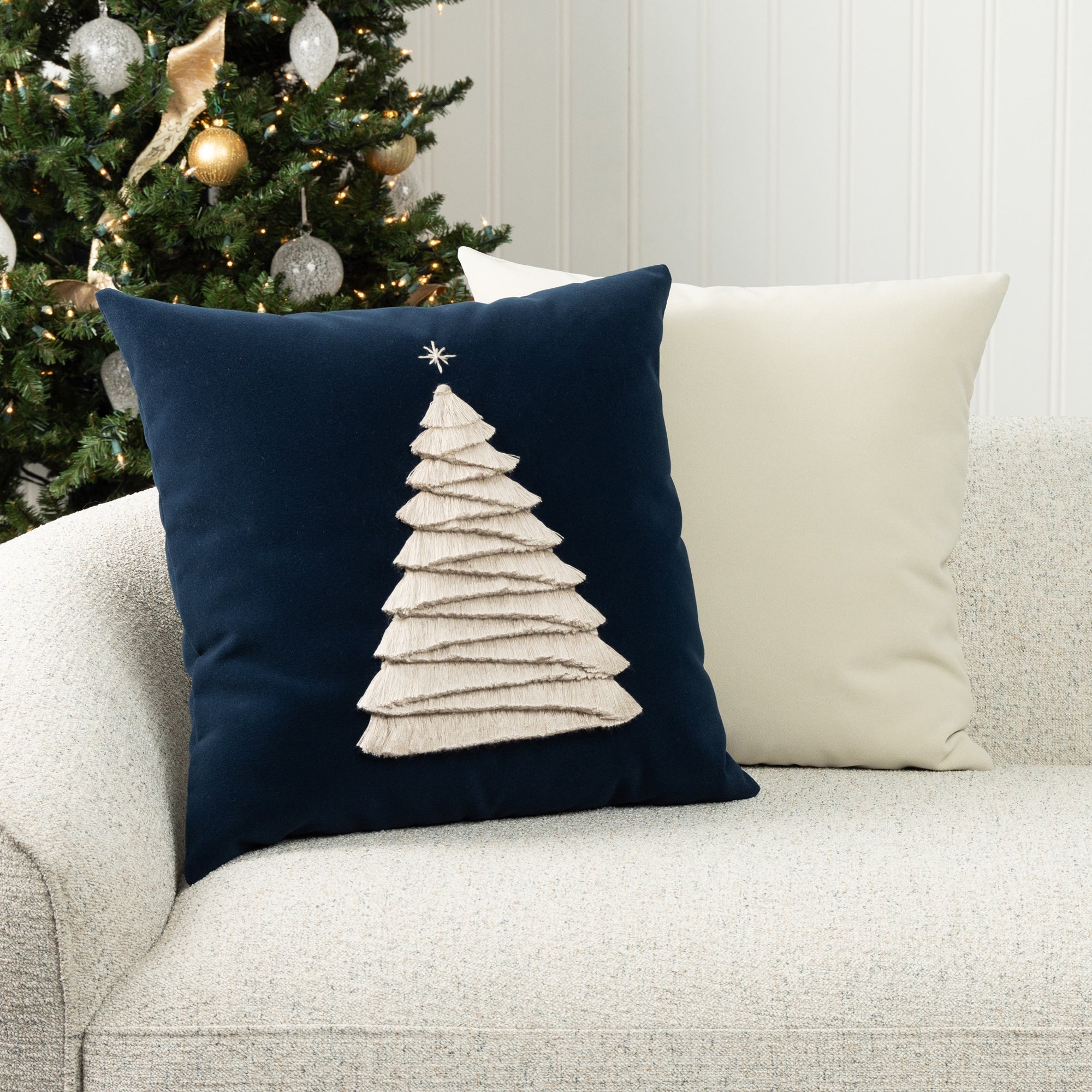 Luxury holiday image of navy holiday accent pillow with hand stitched holiday tree accents and ivory solid pillow both are outdoor safe by elaine smith