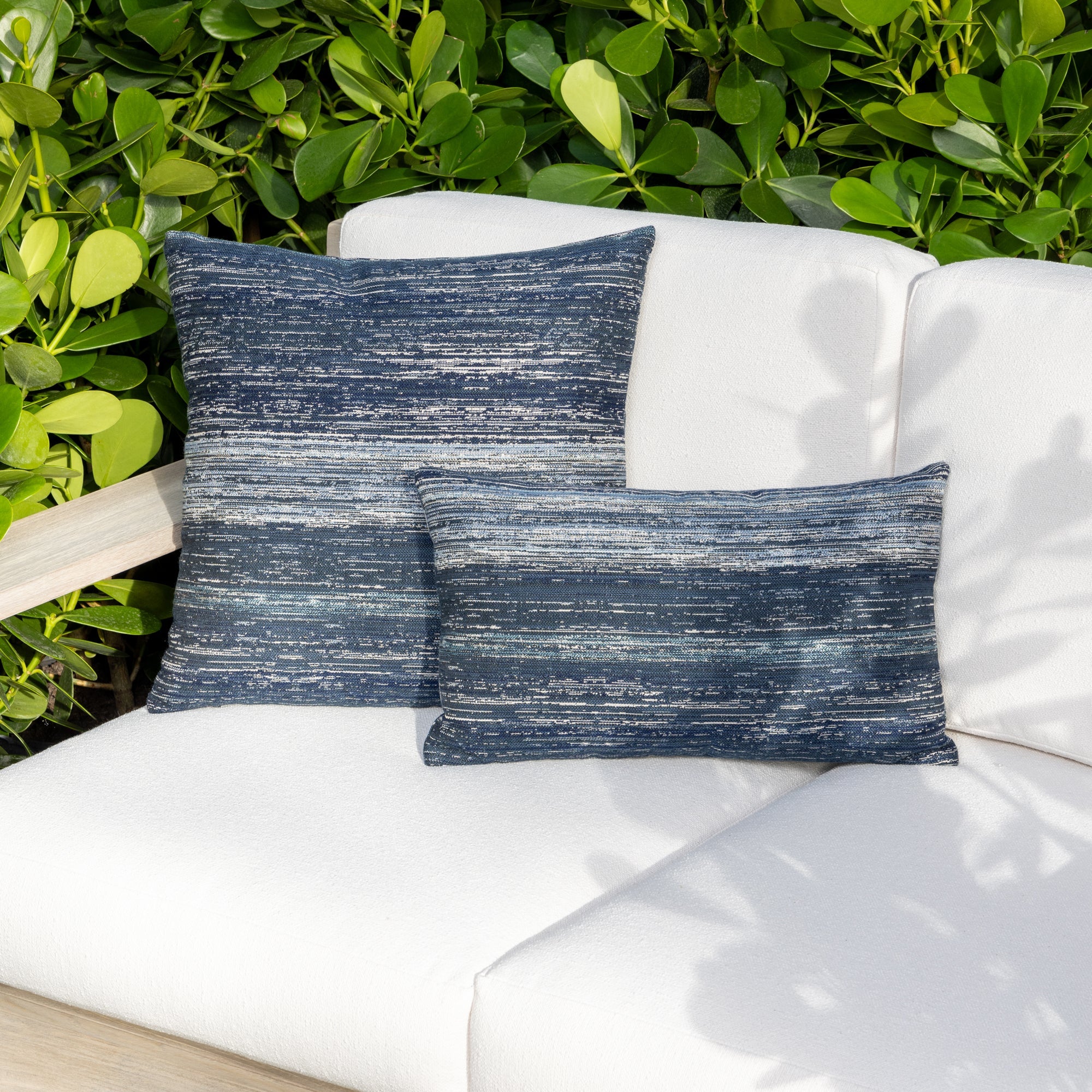 Outdoor image of pillows in Indigo outdoor safe woven textile with streaked texture effect