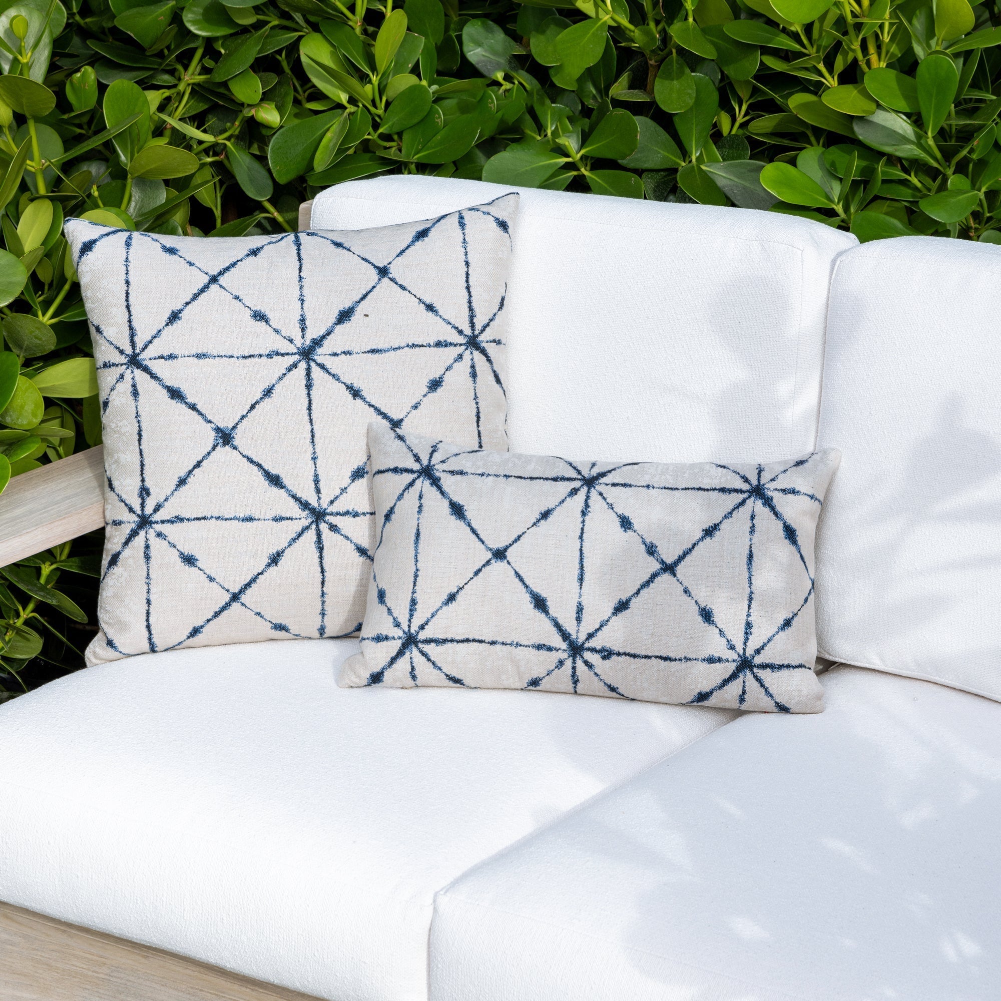 Outdoor image of group of pillows in indigo in variety of patterns, all are outdoor safe
