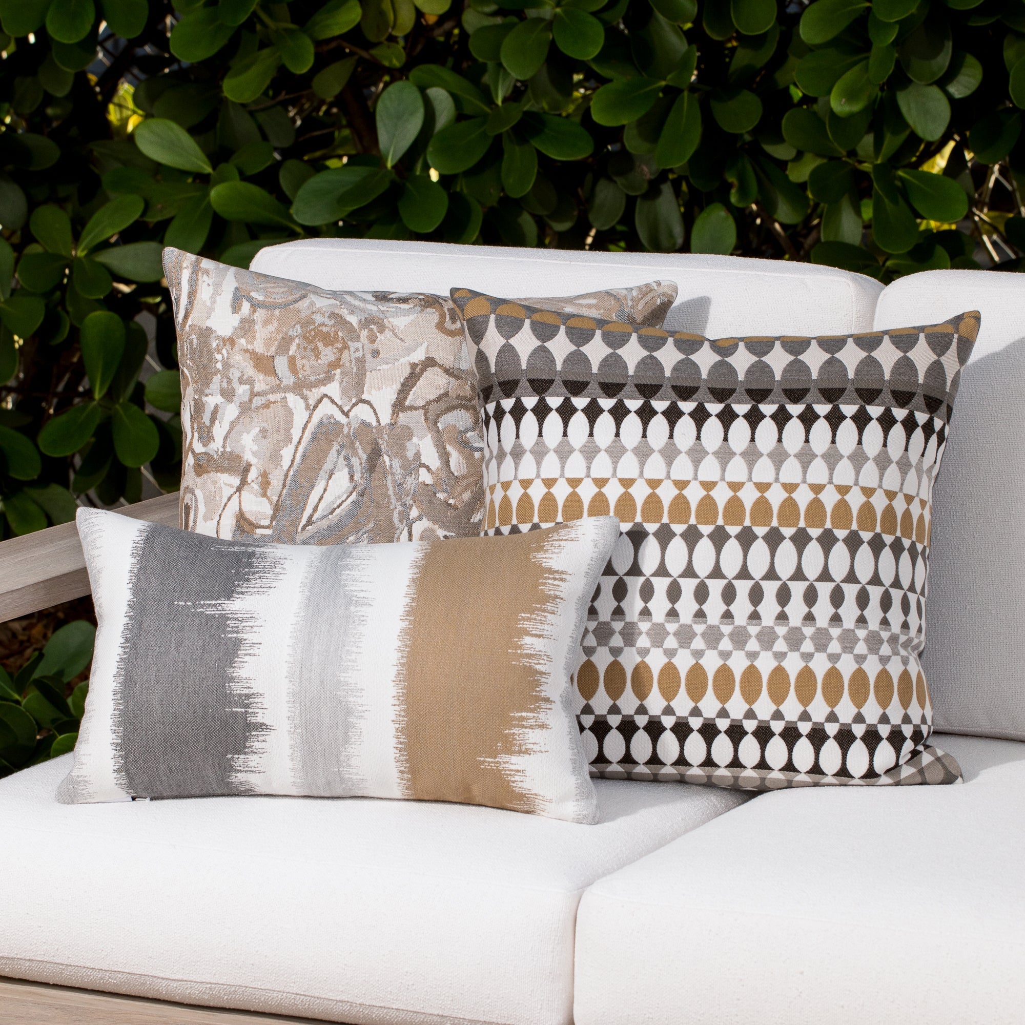 Outdoor image of pillows in Modern Oval Dune – outdoor-safe woven fabric by Elaine Smith, ideal for high-end commercial and residential applications.