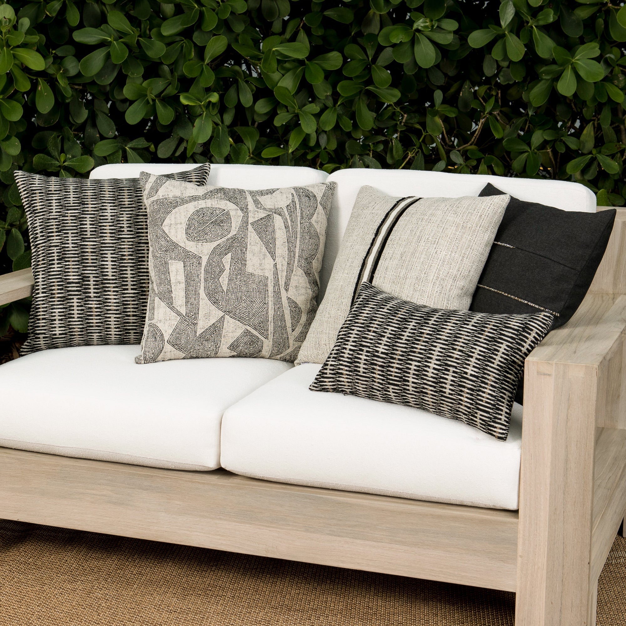 Outdoor image of pillows in Solid carbon black outdoor-safe woven fabric