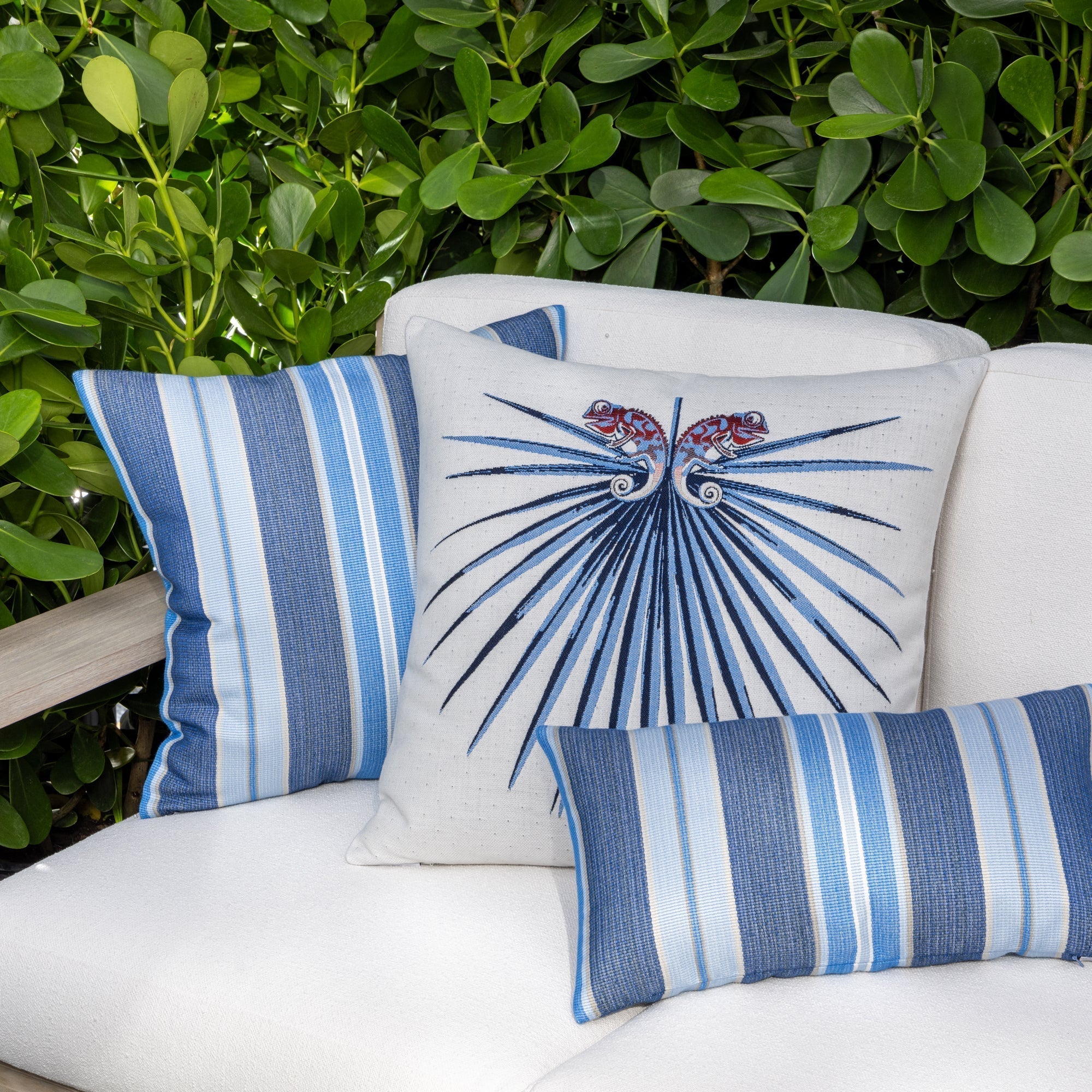 Luxury navy blue botanical patterned lumbar pillow on a outdoor sofa, featuring easy clean performance fabric for luxury hotel and resort design by Elaine Smith