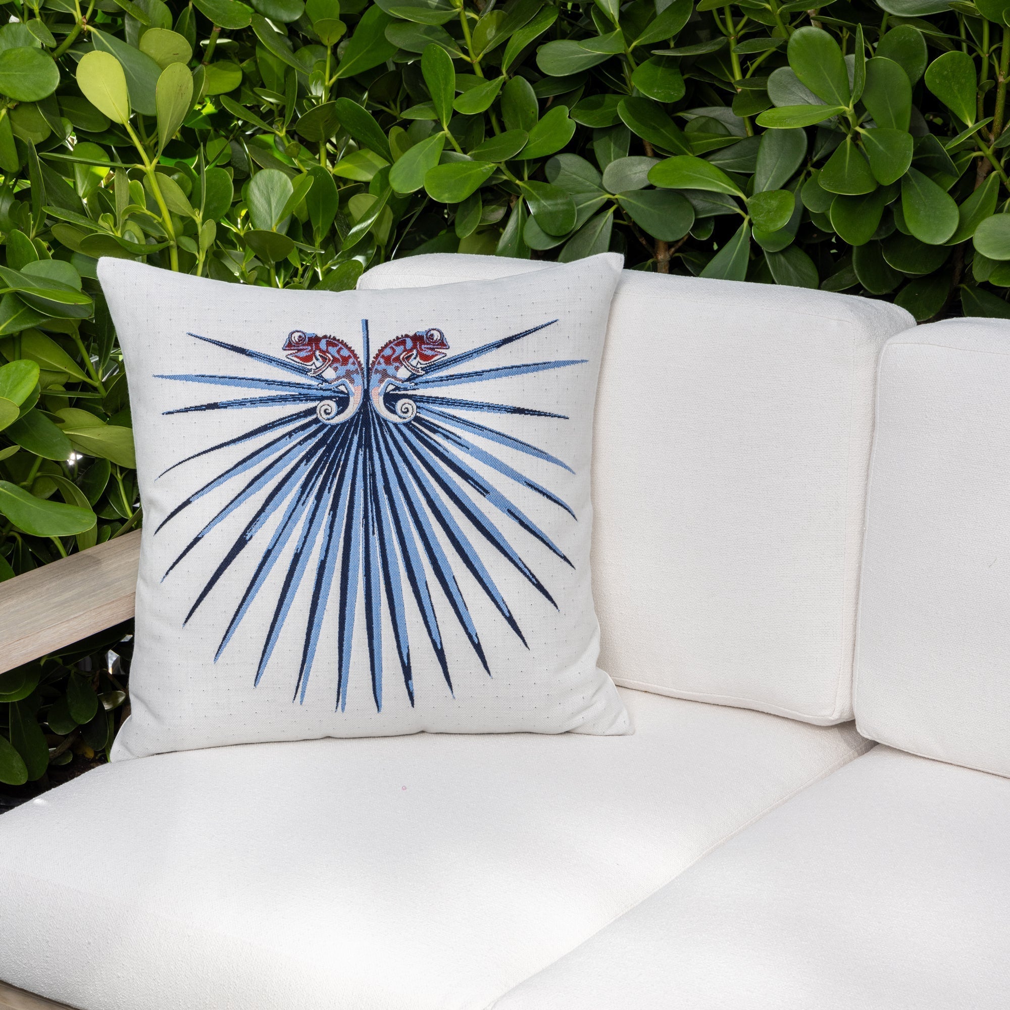 Luxury navy blue botanical patterned lumbar pillow on a outdoor sofa, featuring easy clean performance fabric for luxury hotel and resort design by Elaine Smith