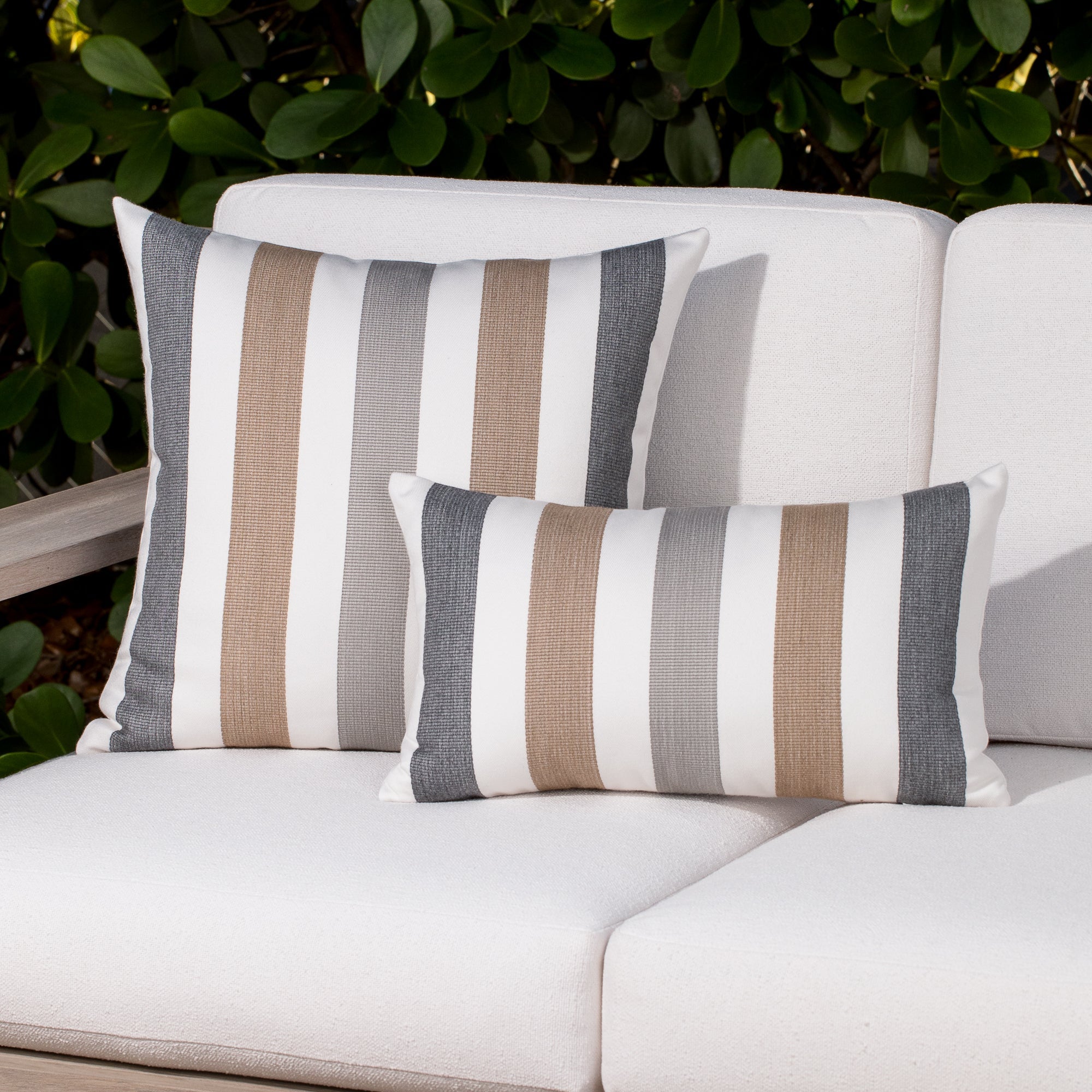 Luxury charcoal two tone decorative pillow on a outdoor sofa styled for hospitality suites, featuring solution dyed performance fibers for hospitality and commercial spaces