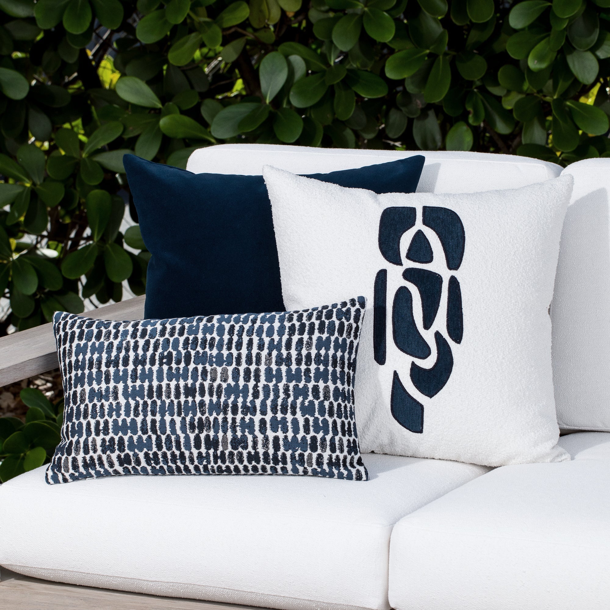 Luxury soft gray botanical patterned bolster pillow on a rooftop seating area, featuring soft touch performance weave for residential and commercial interiors