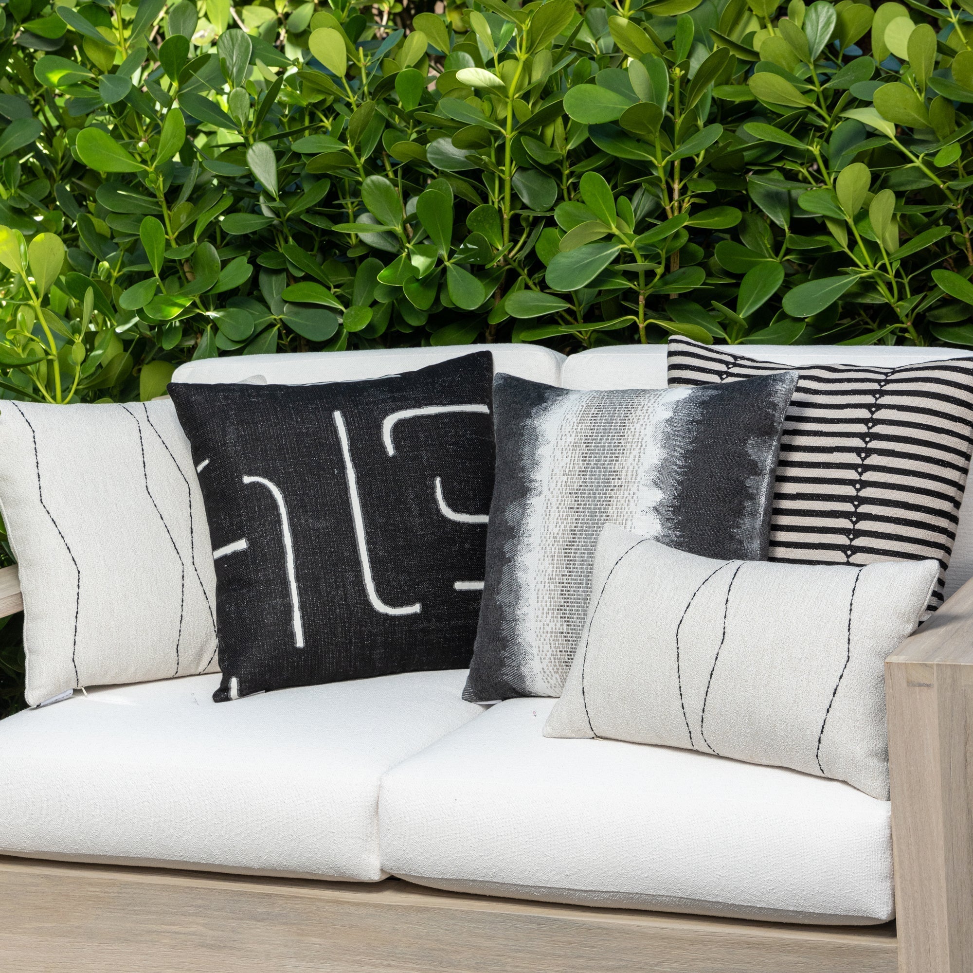 Luxury black and white geometric patterned square pillow on a outdoor sofa, featuring commercial grade construction for luxury hotel and resort design
