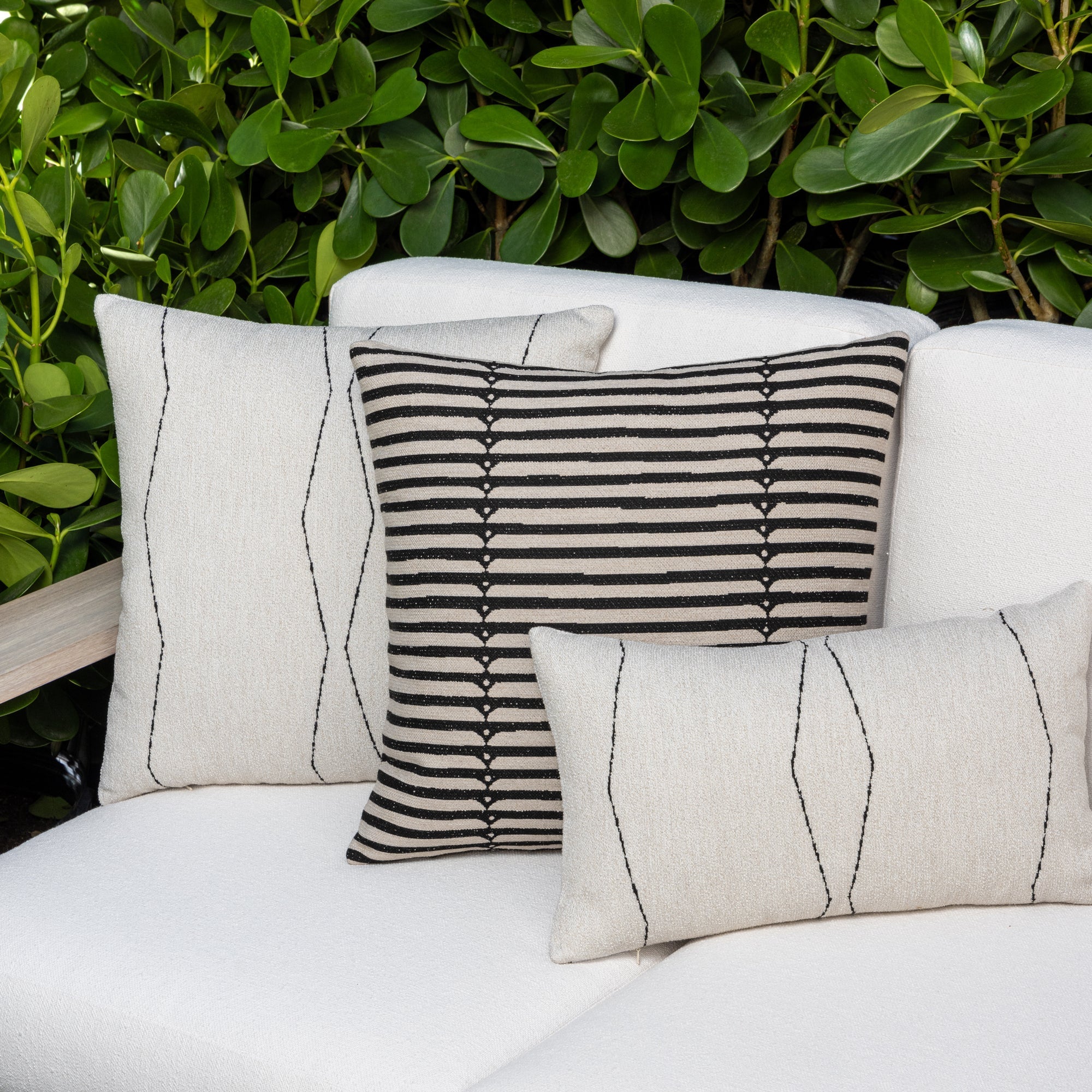 Luxury black and white geometric patterned square pillow on a outdoor sofa, featuring commercial grade construction for luxury hotel and resort design