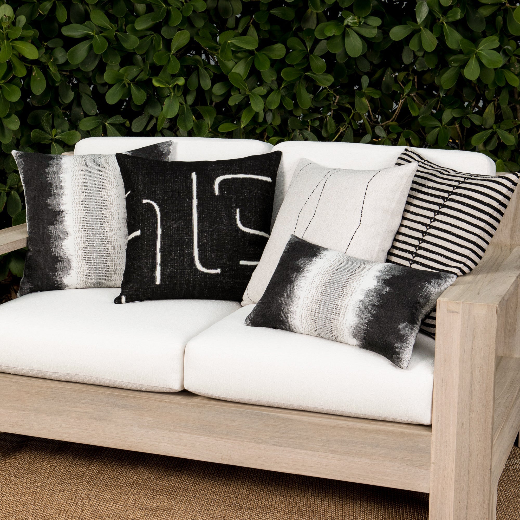Luxury black and white geometric patterned square pillow on a outdoor sofa, featuring commercial grade construction for luxury hotel and resort design