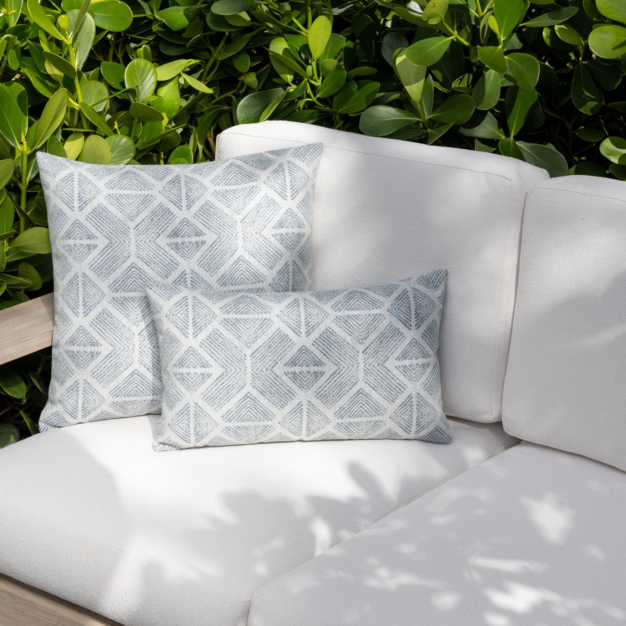 Luxury light blue striped and other soft blue decorative pillows on a outdoor sofa, featuring commercial grade construction for luxury hotel and resort design
