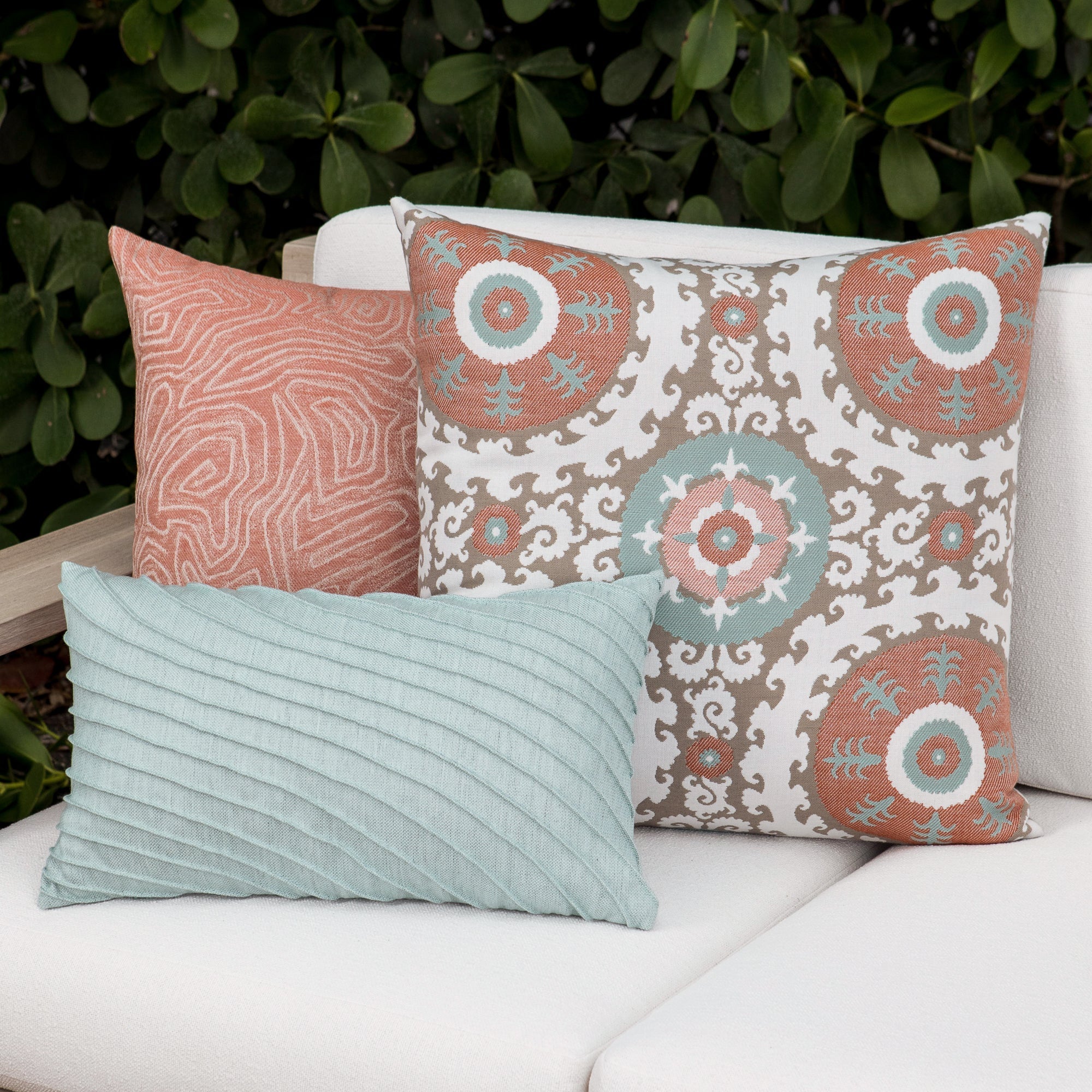 Luxury terracotta tropical leaf patterned accent pillow on an indoor and outdoor sofa, featuring tailored seams for a polished look to complete indoor and outdoor decor by Elaine Smith