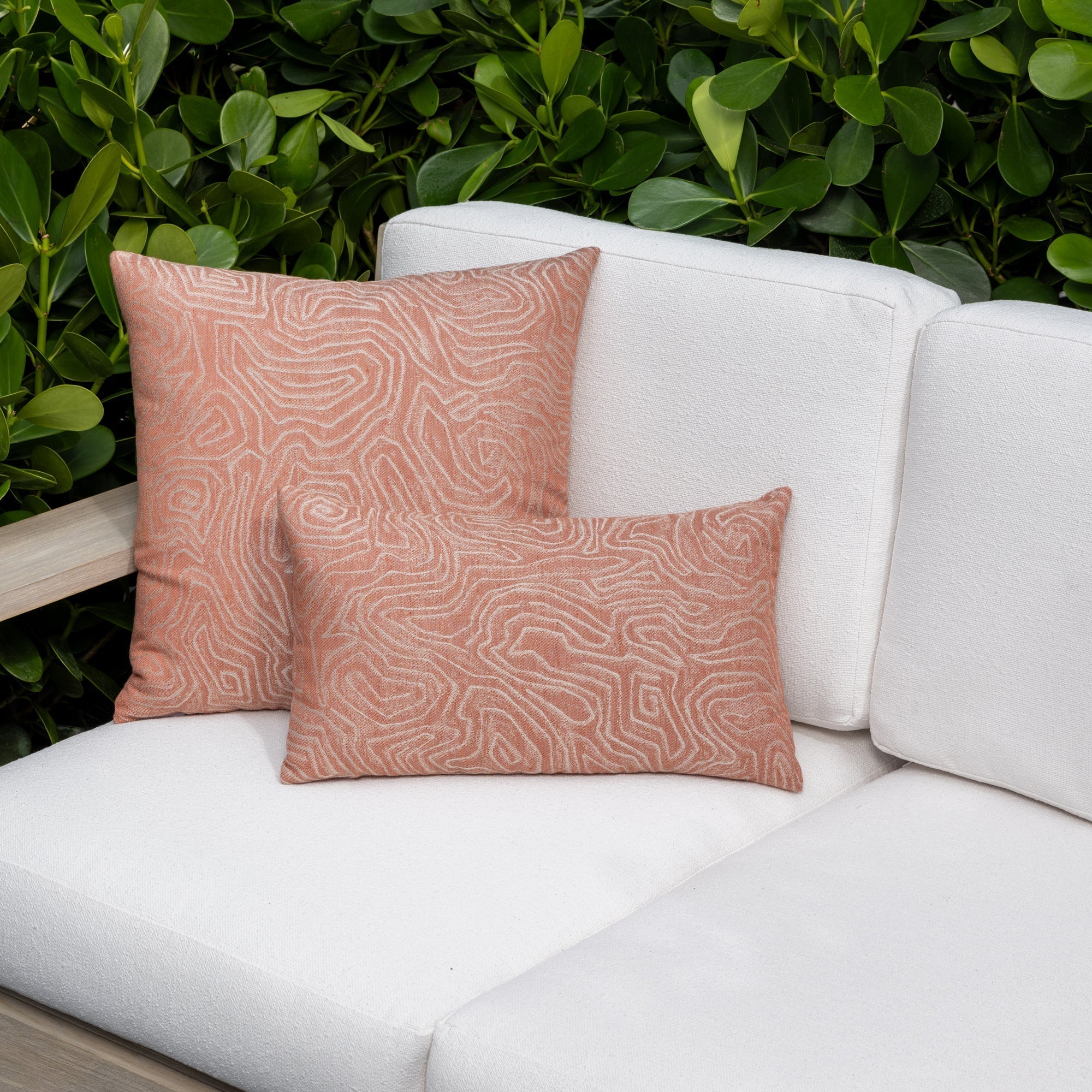 Luxury terracotta tropical leaf patterned accent pillow on an indoor and outdoor sofa, featuring tailored seams for a polished look to complete indoor and outdoor decor by Elaine Smith