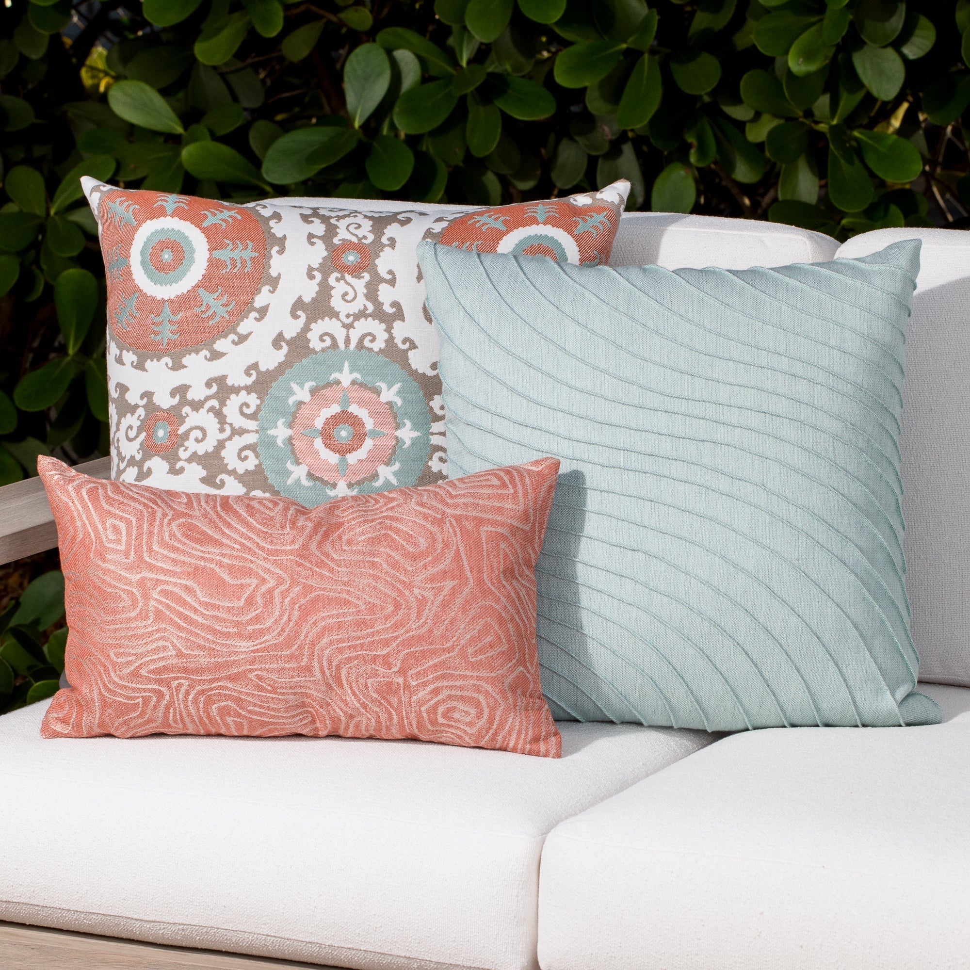 Luxury terracotta tropical leaf patterned accent pillow on an indoor and outdoor sofa, featuring tailored seams for a polished look to complete indoor and outdoor decor by Elaine Smith