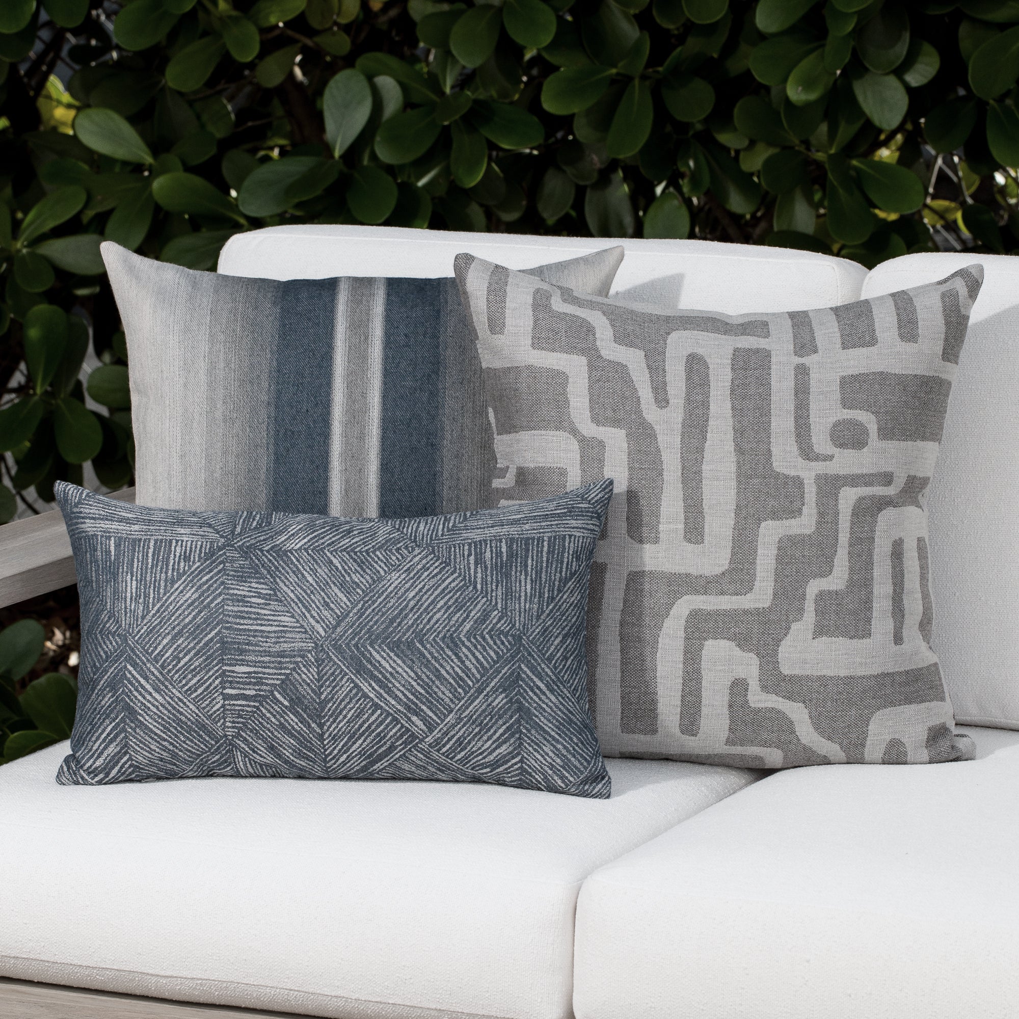 Luxury denim and gray modern patterned decorative pillow on a outdoor sofa, featuring weather resistant performance fabric for indoor and outdoor use by Elaine Smith