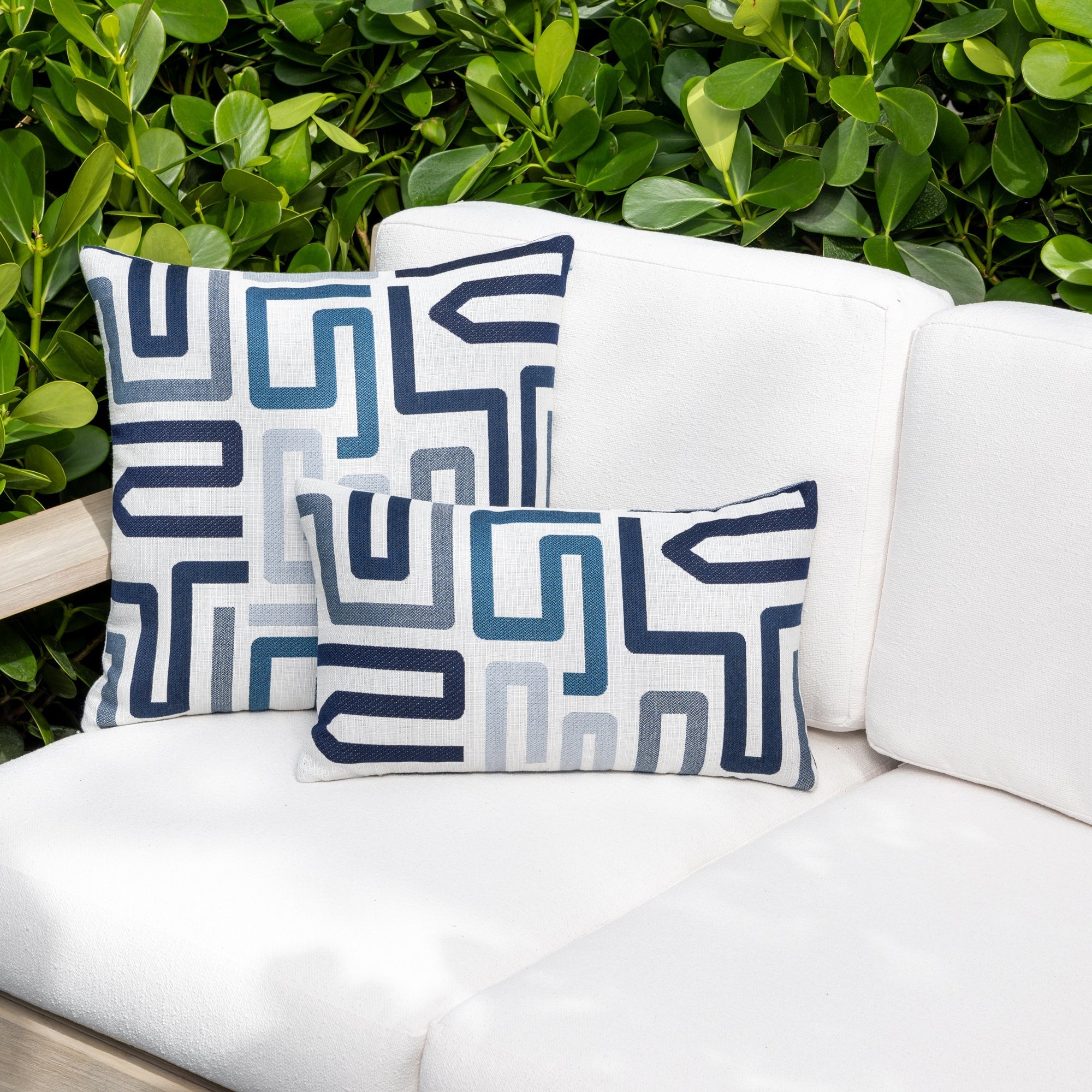 Luxury slate blue textured woven decorative pillow on an indoor and outdoor sofa, featuring commercial grade construction for luxury hotel and resort design