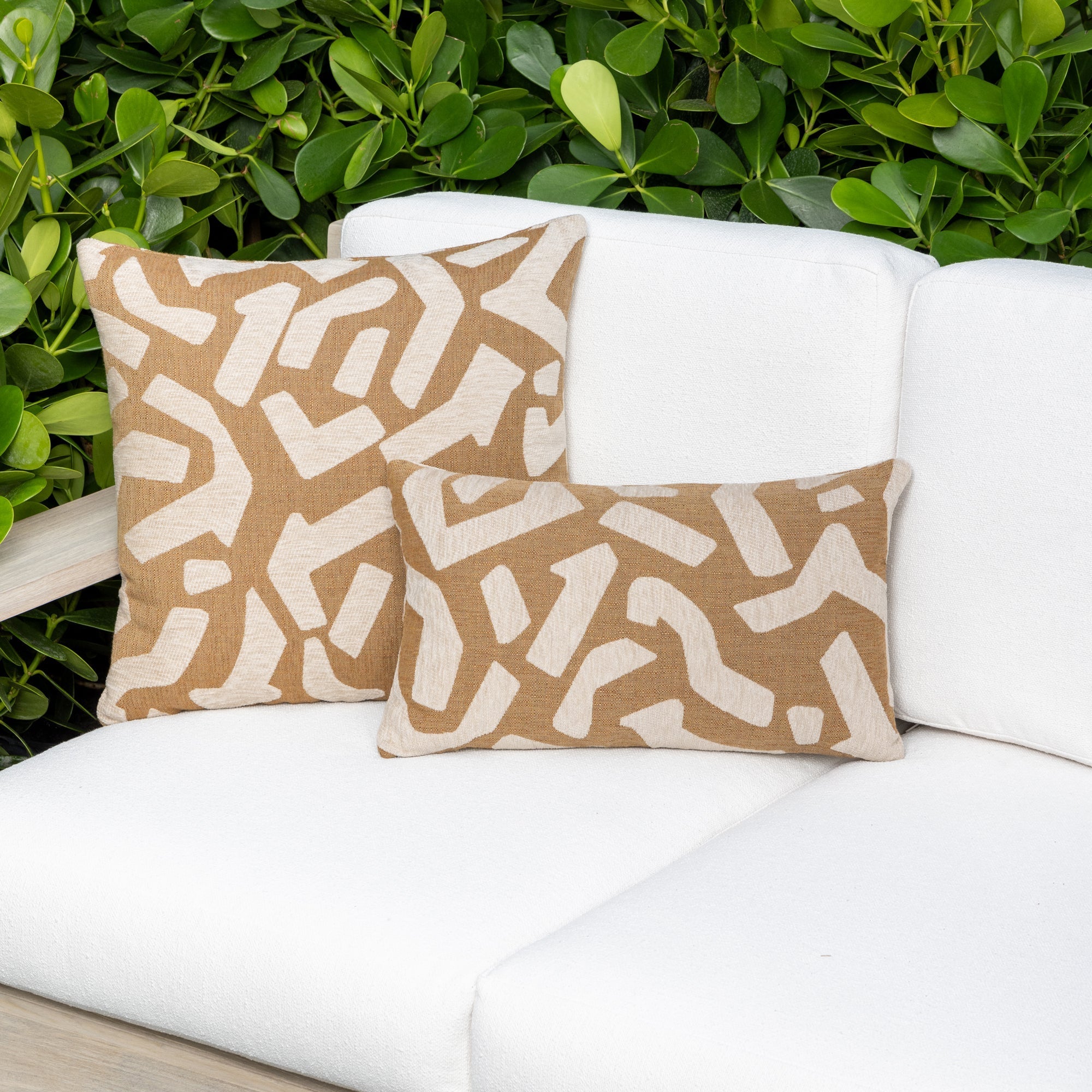 Luxury caramel brown textured woven decorative pillow on an indoor and outdoor sofa, featuring commercial grade construction for luxury hotel and resort design