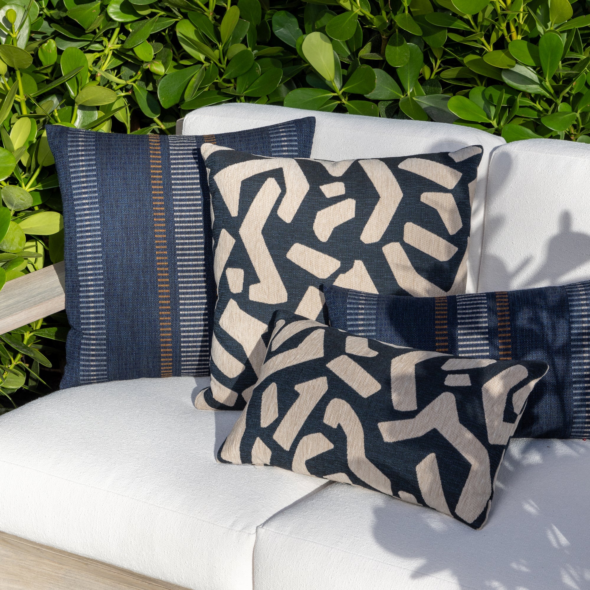 Outdoor image of pillows in Abstract indigo outdoor safe fabric with geometric shapes in flax chenille