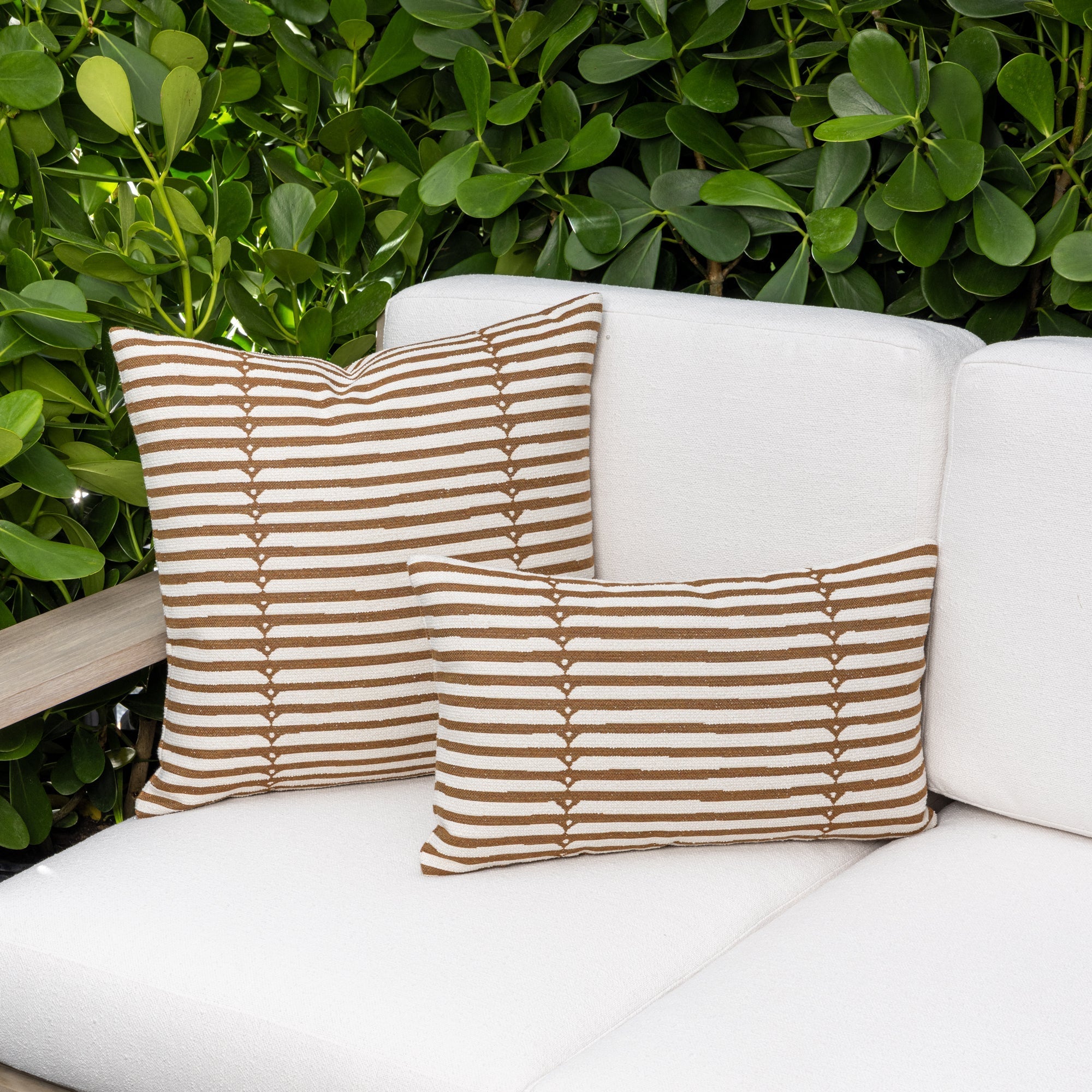 Luxury caramel brown textured woven decorative pillow on an indoor and outdoor sofa, featuring commercial grade construction for luxury hotel and resort design