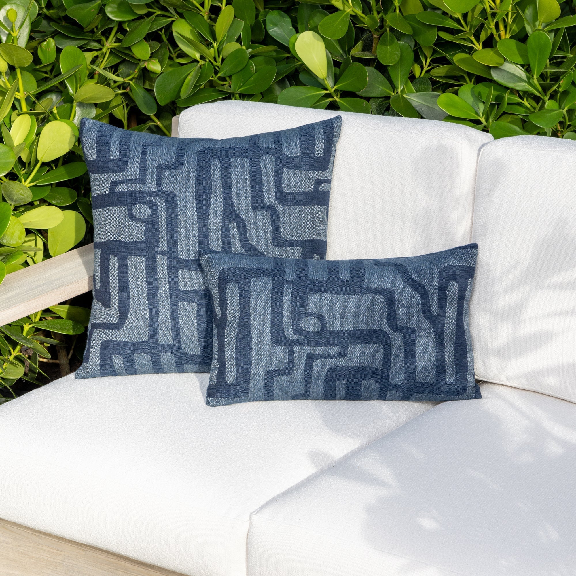 Luxury indigo blue textured woven decorative pillow on an indoor and outdoor sofa, featuring commercial grade construction for luxury hotel and resort design