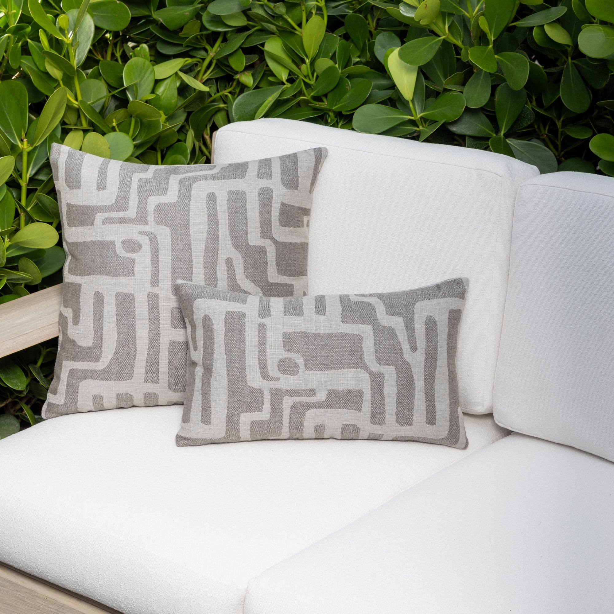 Luxury pewter gray textured woven decorative pillow on an indoor and outdoor sofa, featuring commercial grade construction for luxury hotel and resort design