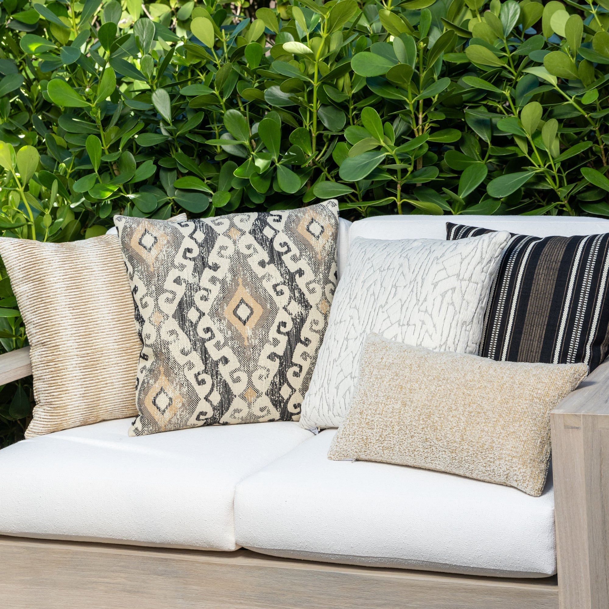 Luxury neutral striped decorative pillow on a outdoor sofa styled for hospitality suites, featuring weather resistant performance fabric for indoor and outdoor use by Elaine Smith
