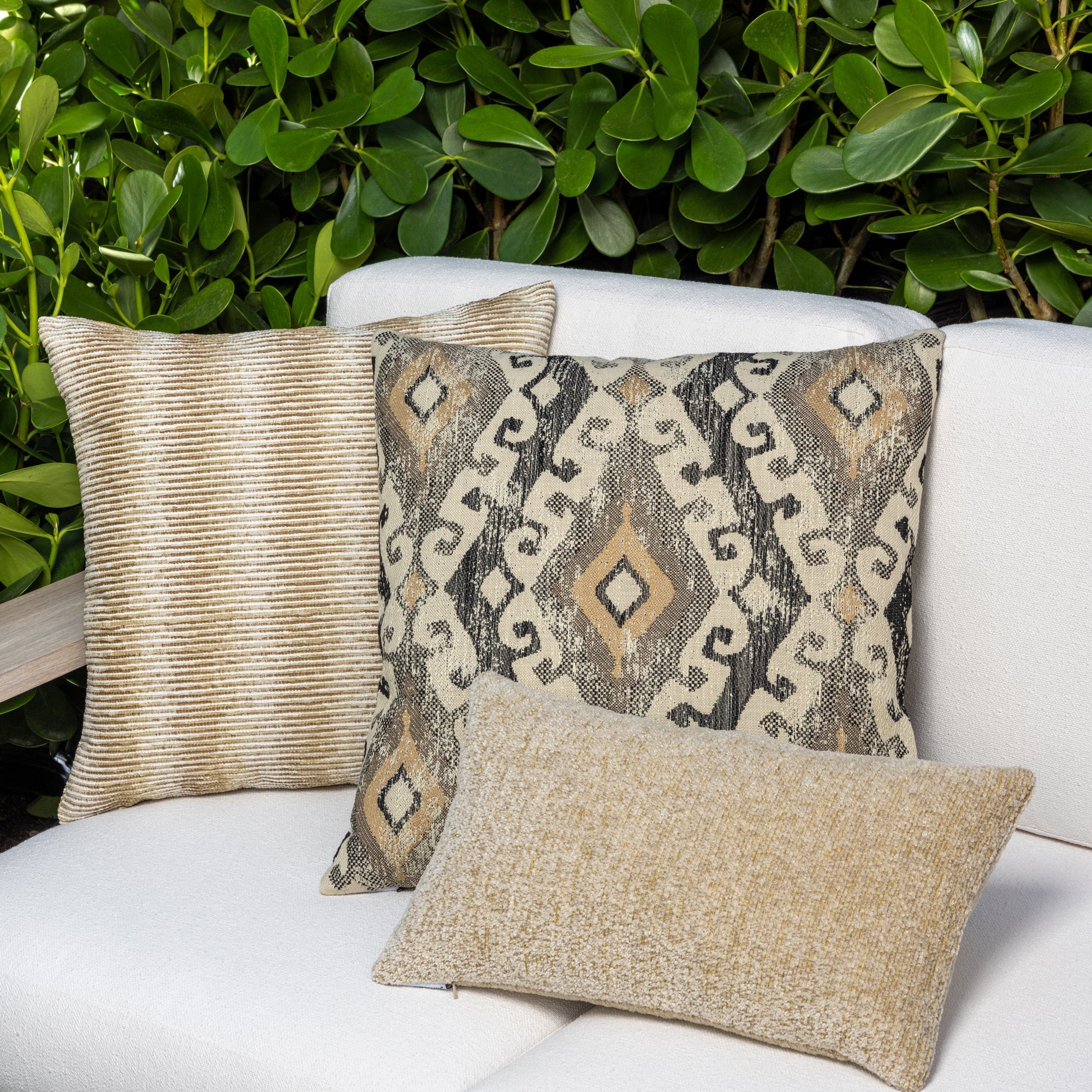 Luxury neutral striped decorative pillow on a outdoor sofa styled for hospitality suites, featuring weather resistant performance fabric for indoor and outdoor use by Elaine Smith