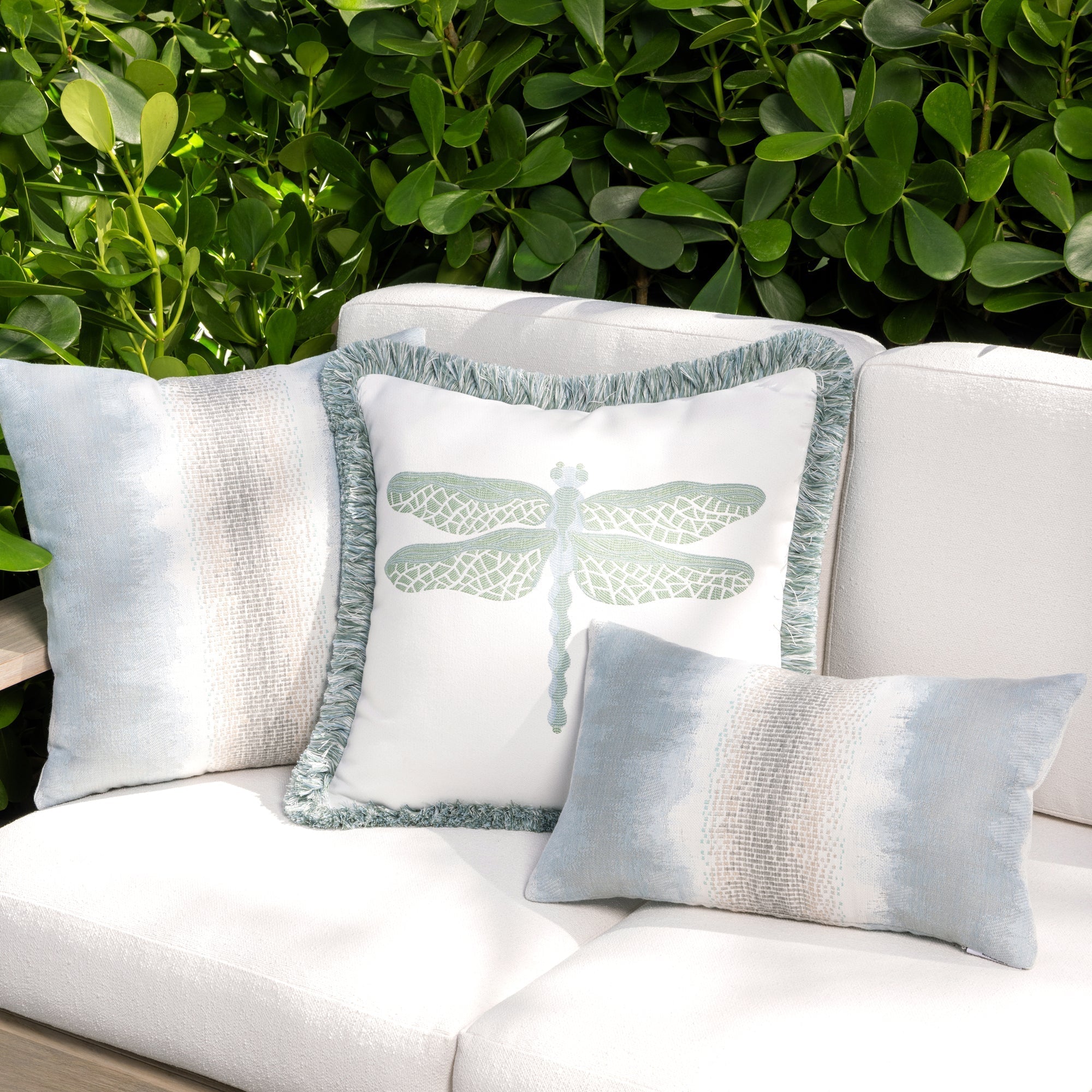 Luxury light blue and white solid throw pillow on an indoor and outdoor sofa, featuring UV and fade resistant fabric to complete indoor and outdoor decor