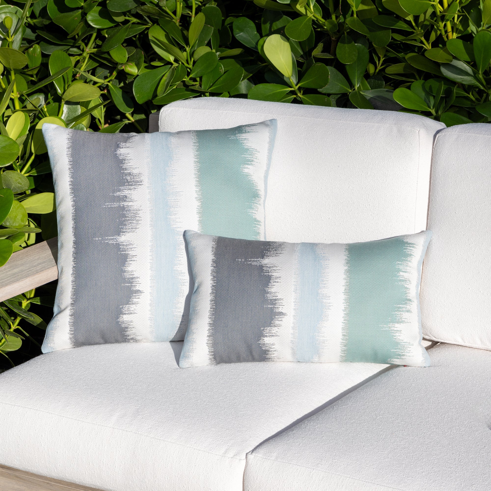 Outdoor image of pillows in Murmur Surf – outdoor-safe woven fabric by Elaine Smith, ideal for high-end commercial and residential applications.