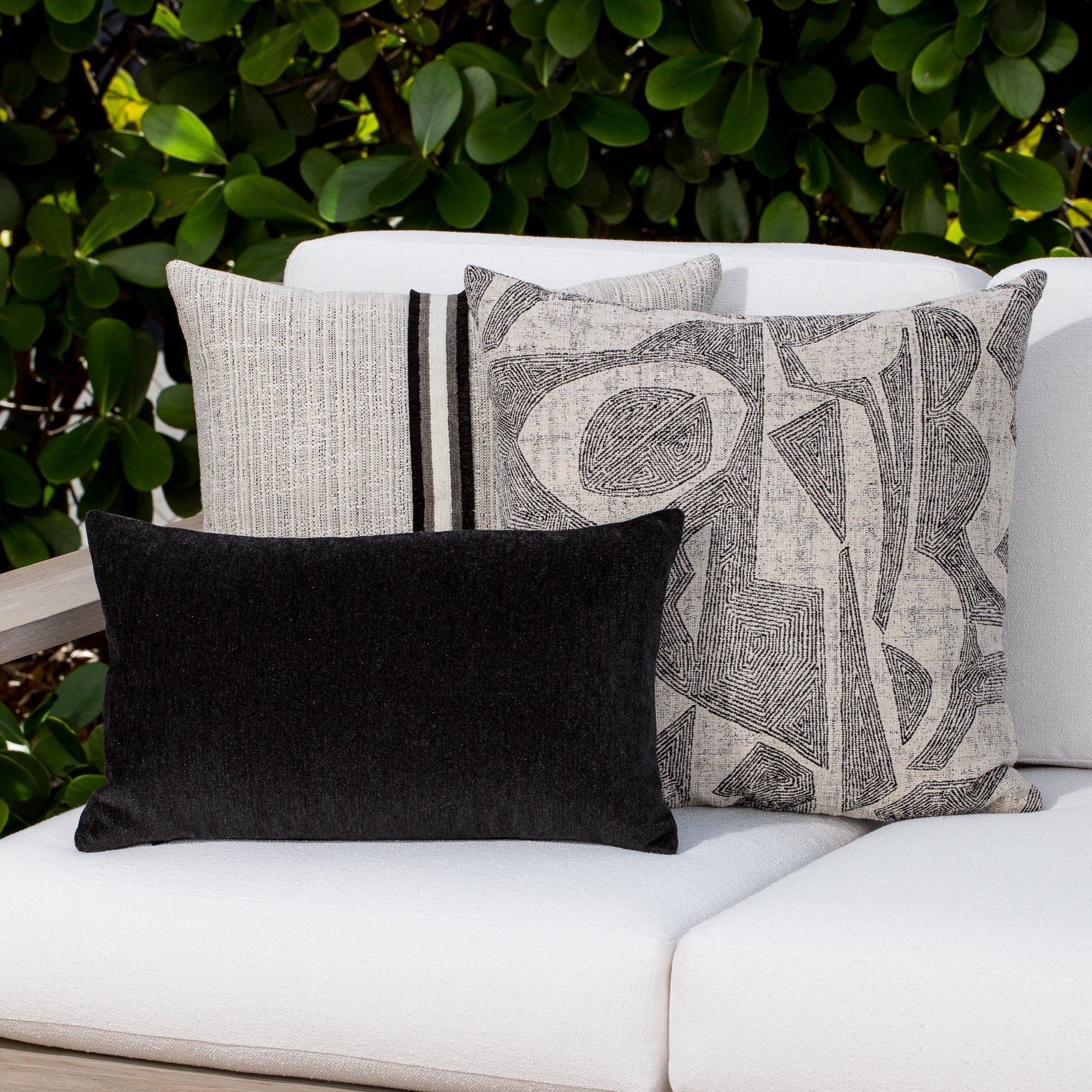 Luxury neutral botanical patterned pillows on a outdoor sofa, featuring rich texture for layered decor for indoor and outdoor use