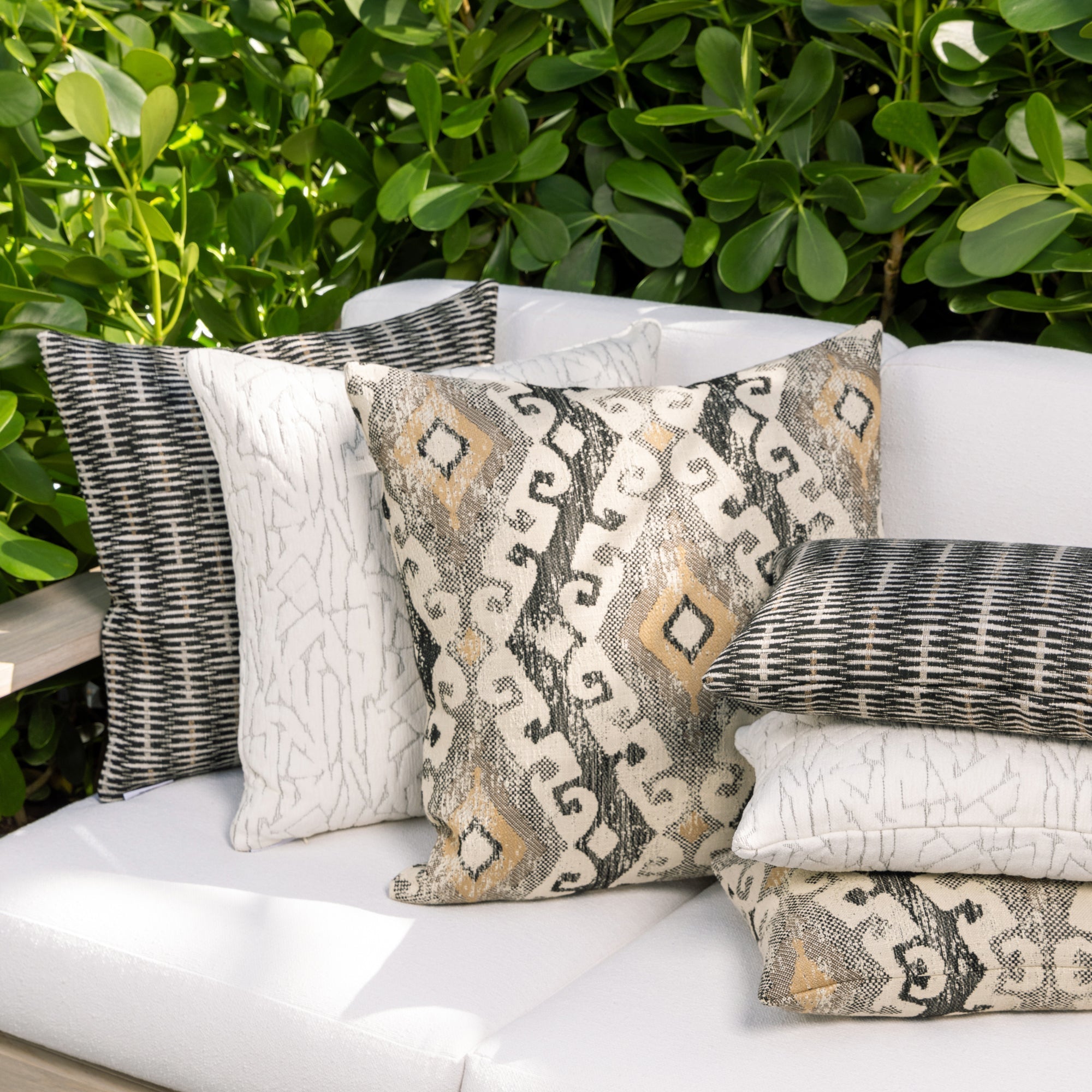 Luxury neutral botanical patterned pillows on a outdoor sofa, featuring rich texture for layered decor for indoor and outdoor use