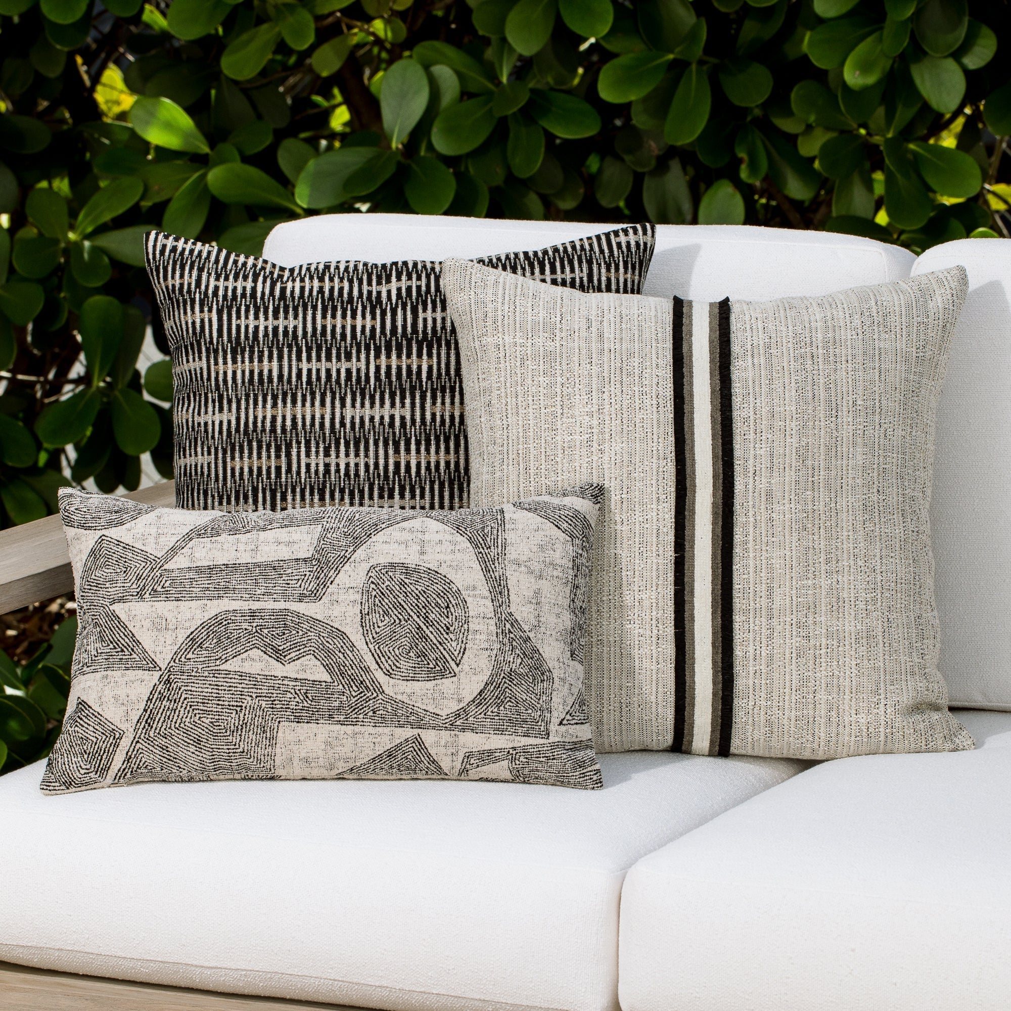 Luxury neutral botanical patterned pillows on a outdoor sofa, featuring rich texture for layered decor for indoor and outdoor use
