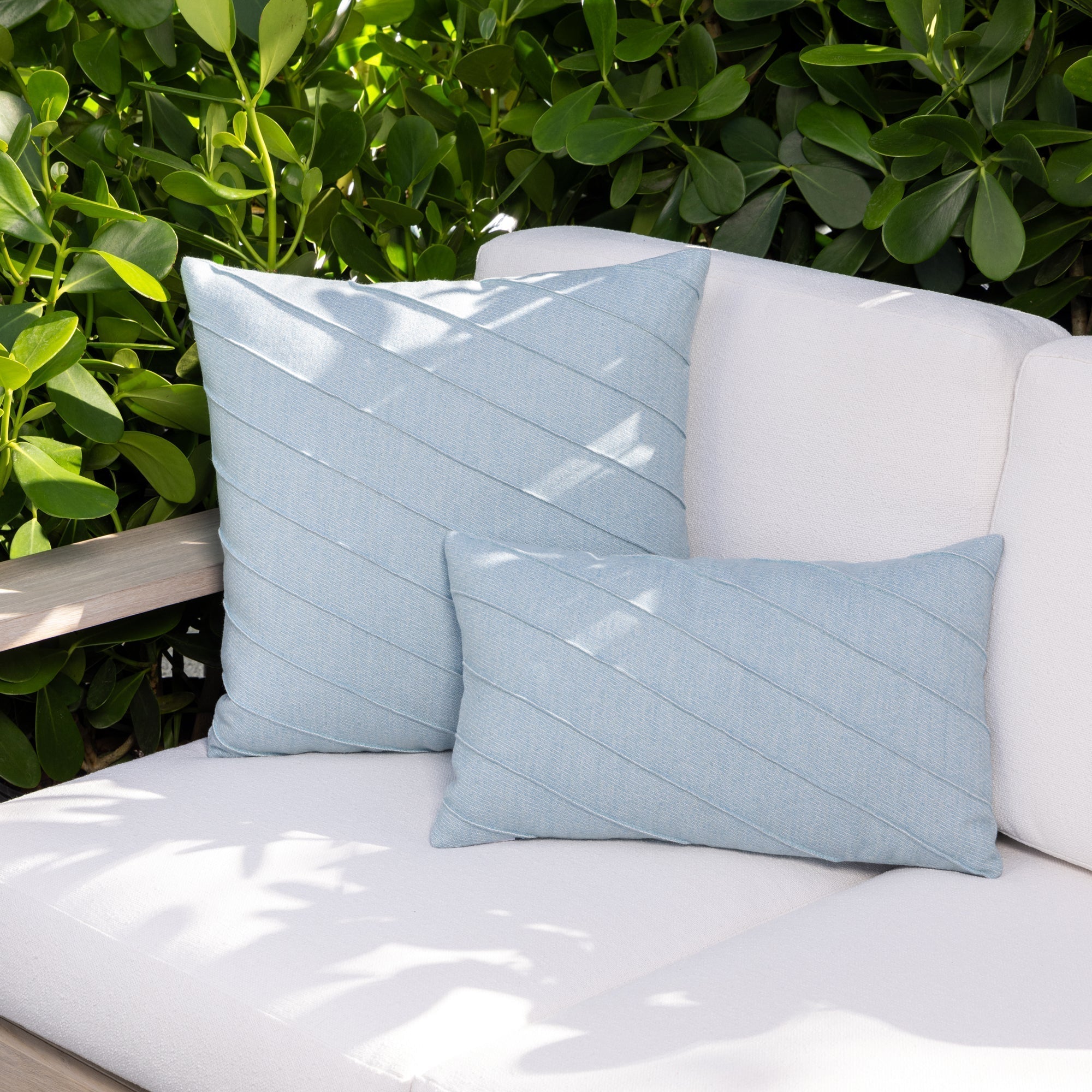 Luxury soft blue accent cushion on a outdoor sofa, featuring UV and fade resistant fabric to complete indoor and outdoor decor
